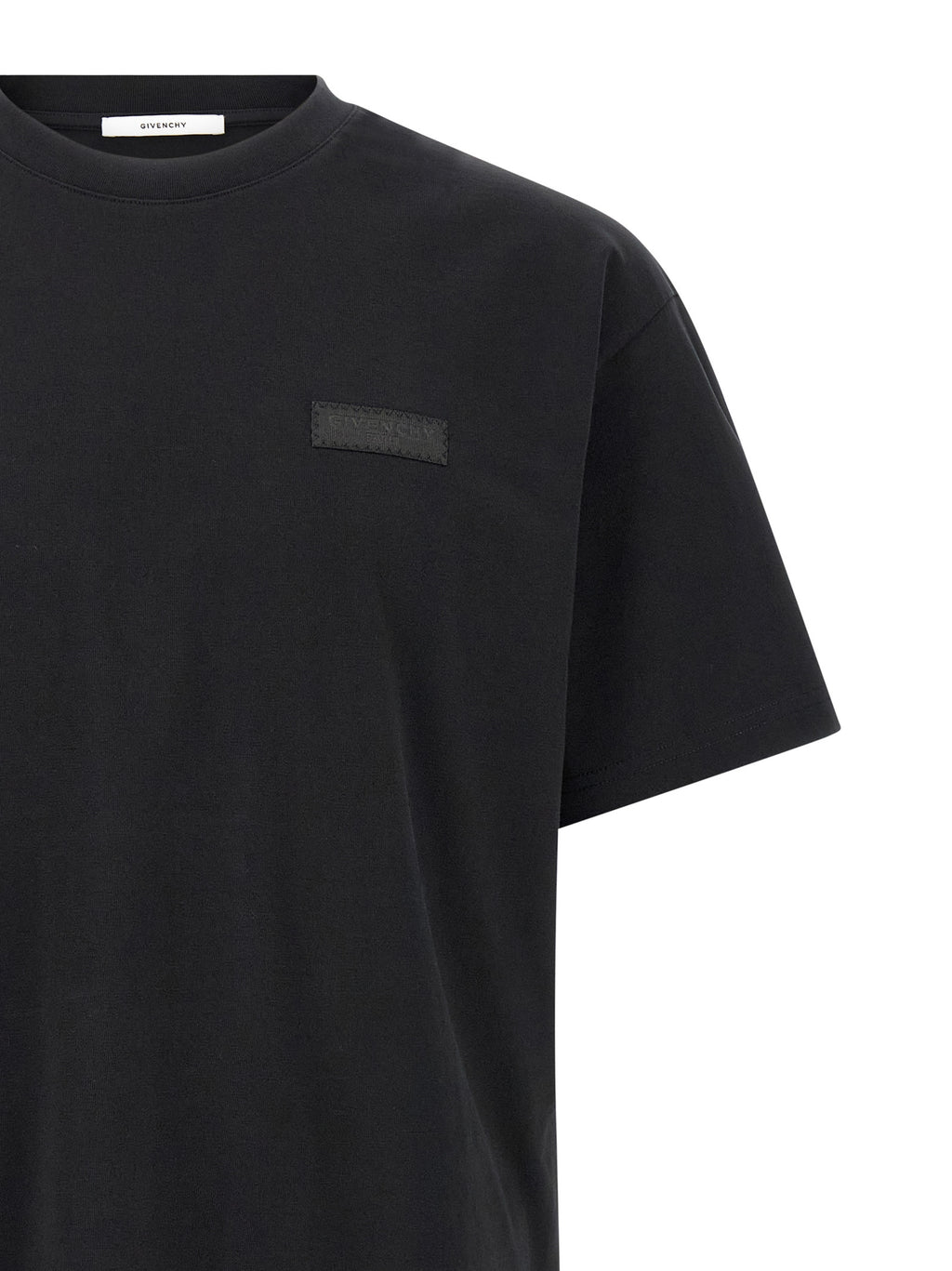 T-shirt noir en coton Givenchy, coupe classique, avec logo discret en haut à gauche, porté sur un mannequin.