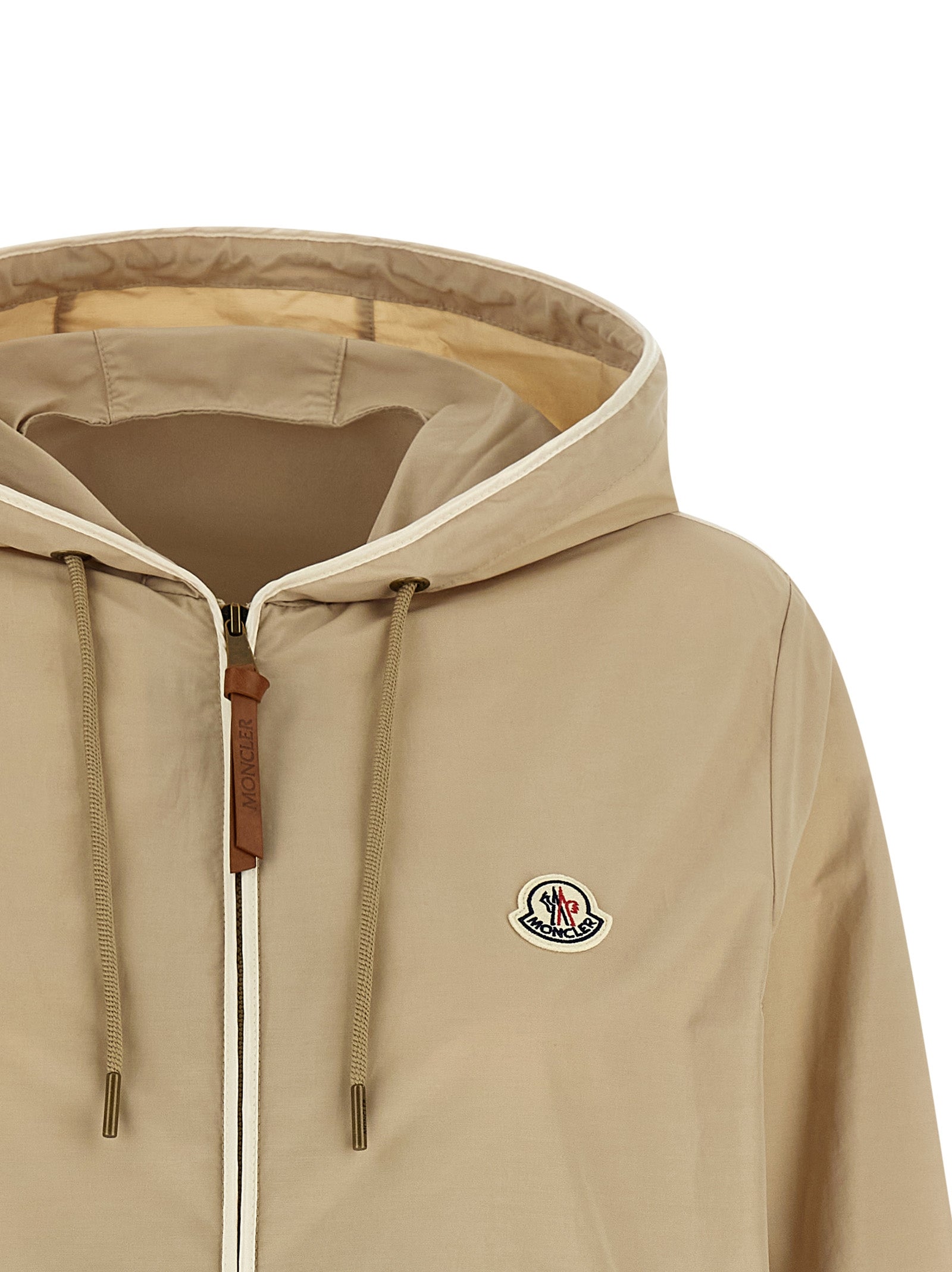 Veste en polyester beige de Moncler, coupe-vent et chaude, avec capuche et fermeture zippée.