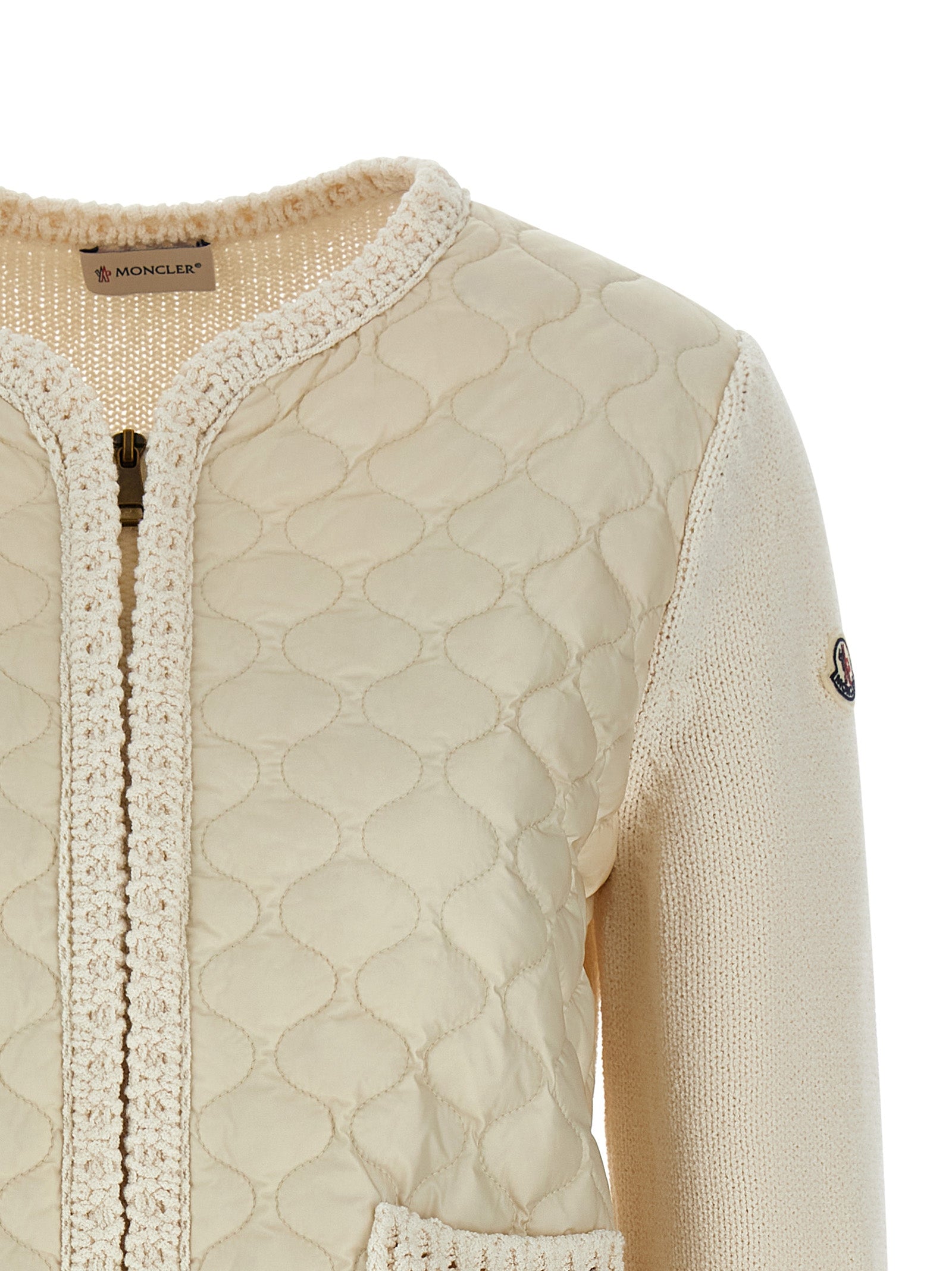 Cardigan beige en coton de la marque Moncler, doux et confortable, avec boutons et logo discret visible sur l'image.