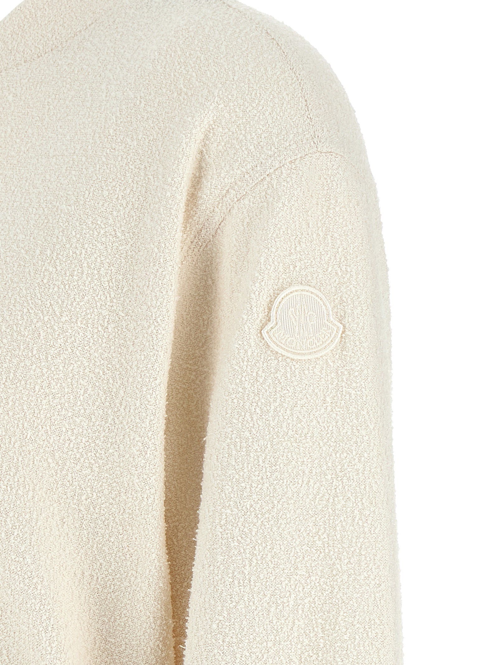 Cardigan en polyester blanc de la marque Moncler, détail du tissu et coupe élégante visible dans l'image.