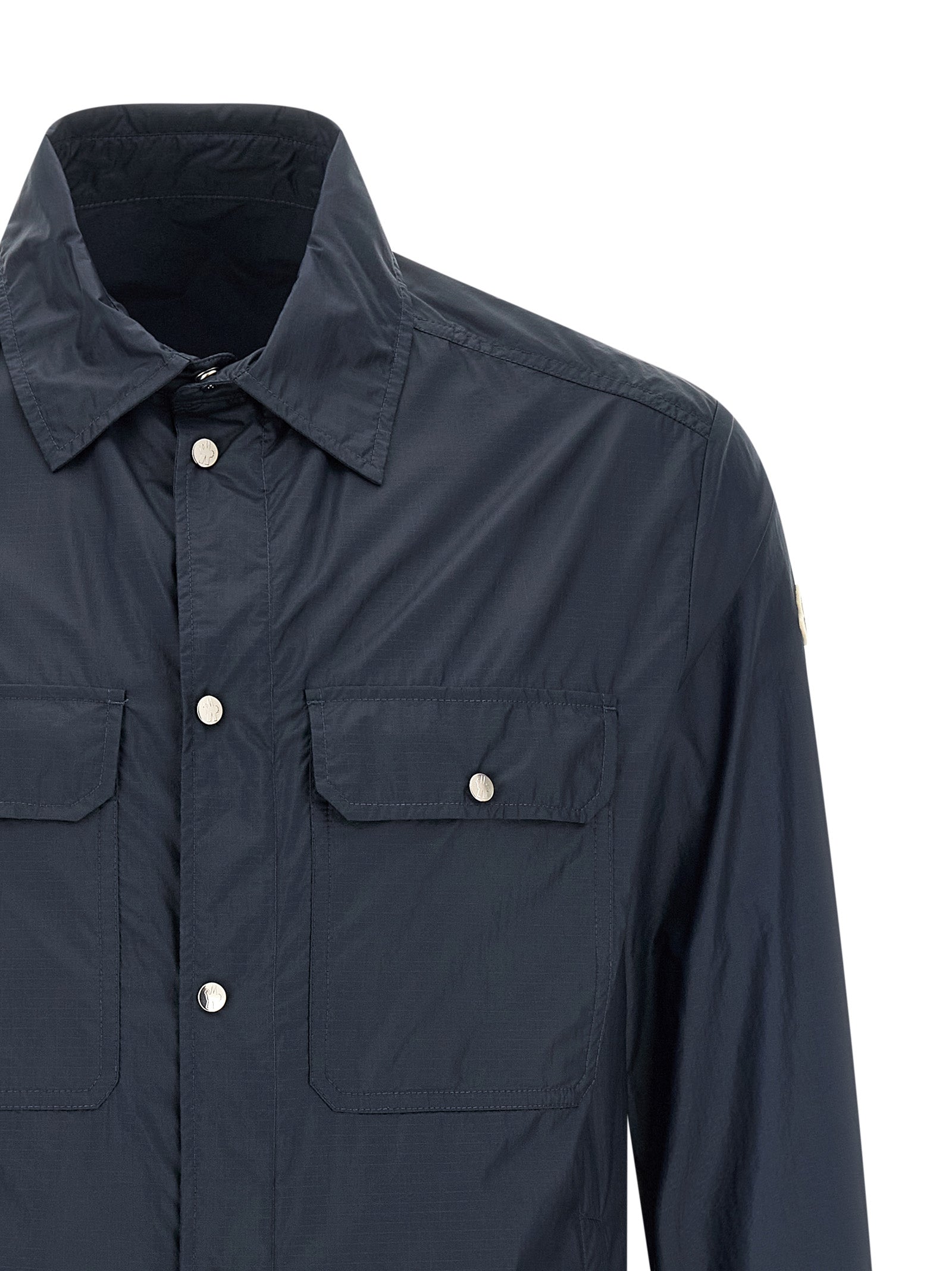 Chemise en polyamide bleue Moncler avec col et manches longues, tissu léger et élégant.