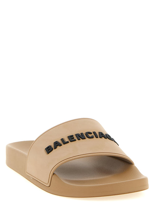 Sandales en plastique beige de Balenciaga, avec design moderne et confortable, visibles sur une modèle.