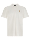 Chemise polo blanche en coton de la marque Versace, vue en gros plan avec col et logo distinctifs visibles.