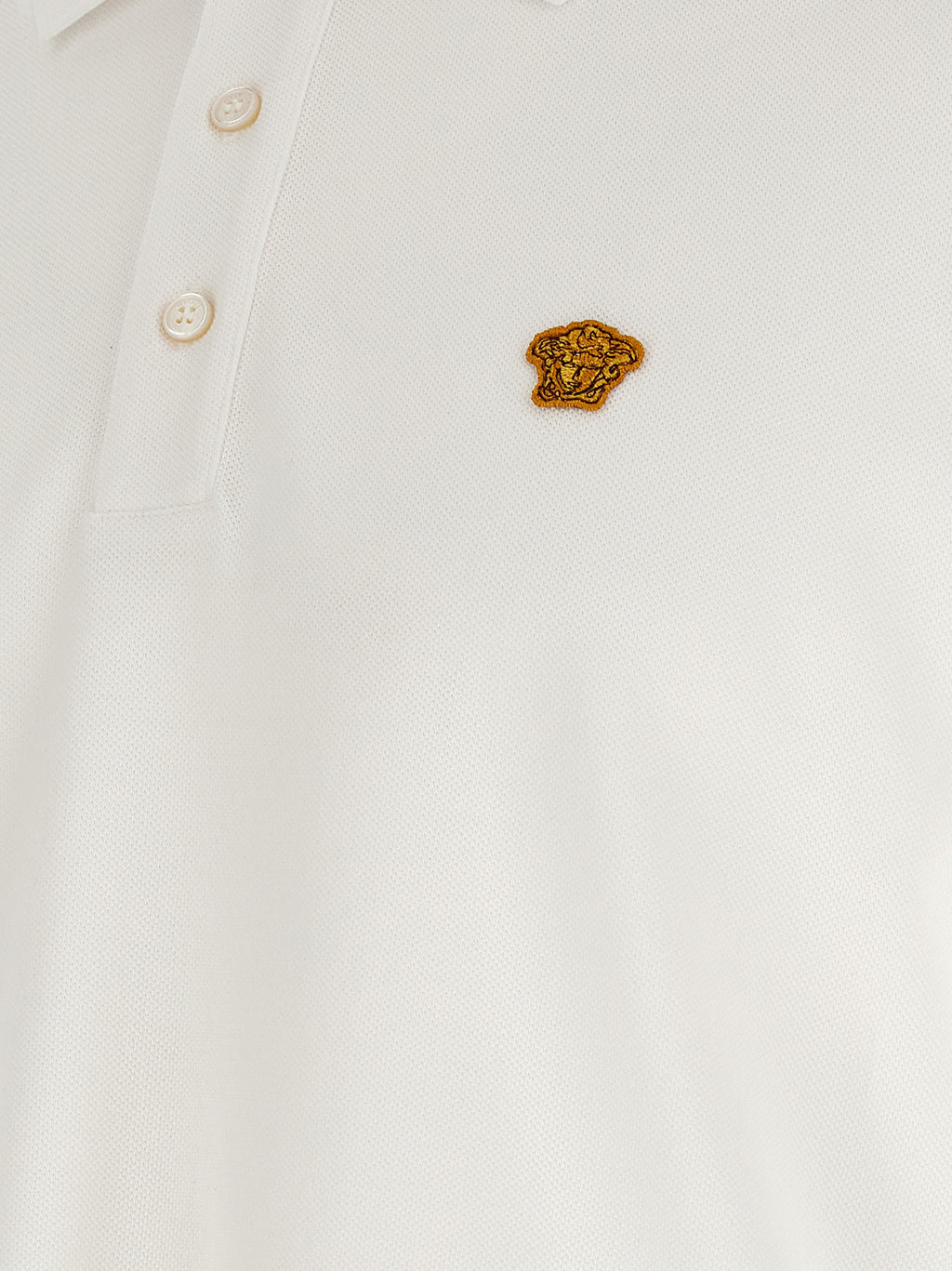 Chemise polo blanche en coton de Versace, détail élégant avec logo de la marque, tissu doux et confortable.