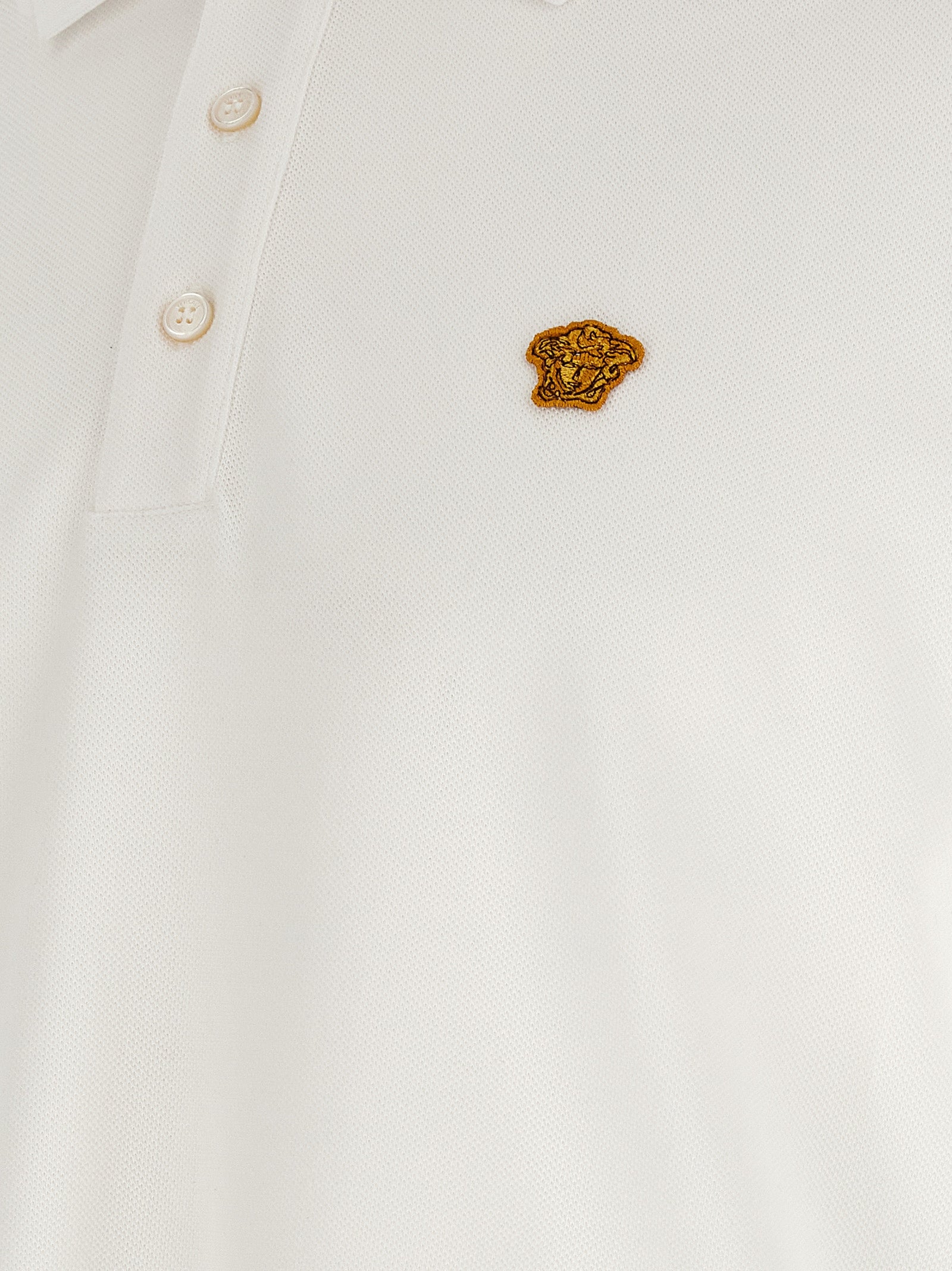 Chemise polo blanche en coton de Versace, détail élégant avec logo de la marque, tissu doux et confortable.