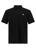 Chemise polo en coton noir de la marque Versace, élégante et classique, avec logo distinctif sur la poitrine.