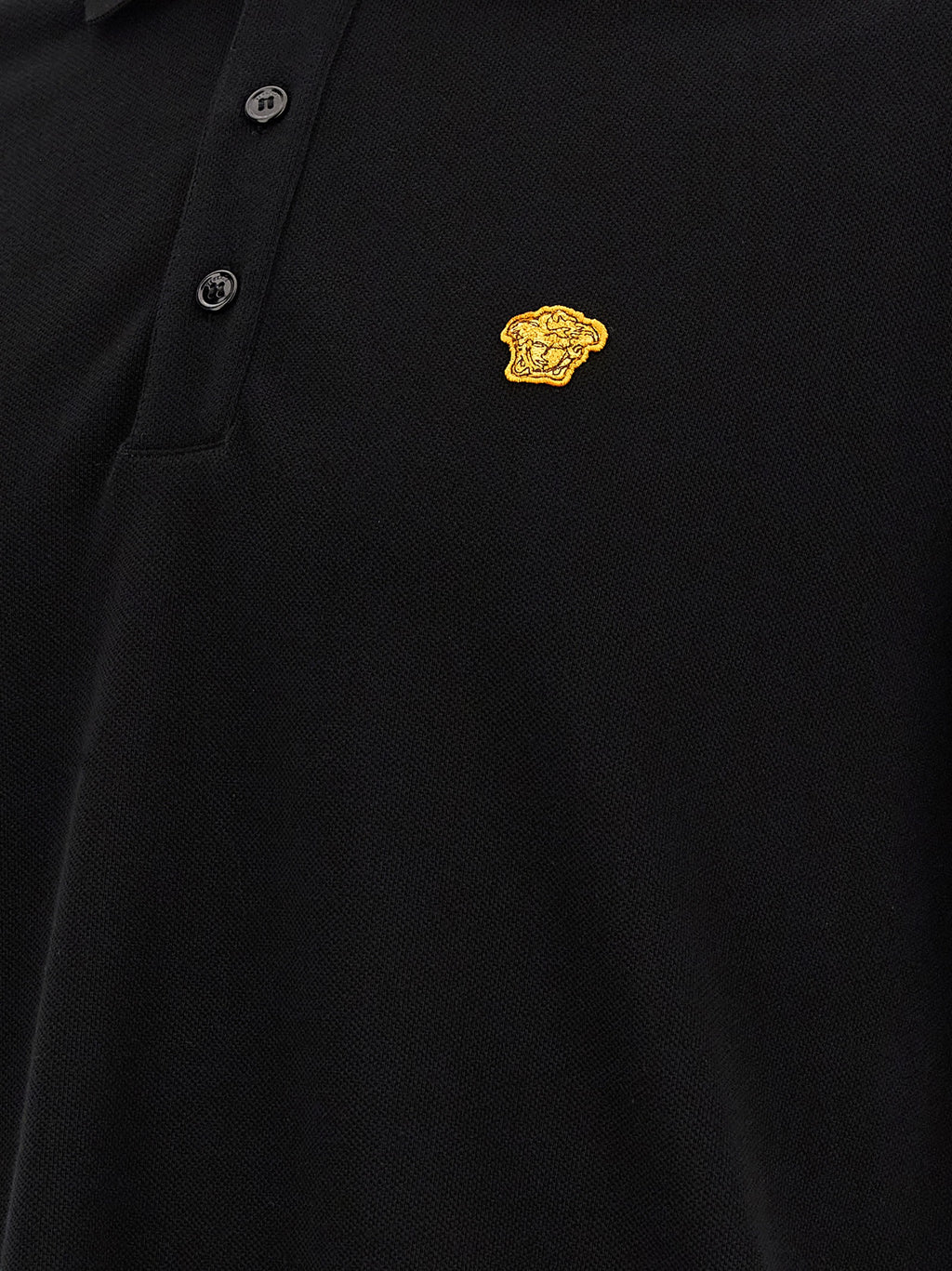 Chemise polo noire en coton Versace avec logo distinctif, manches courtes et col classique, vue de face.
