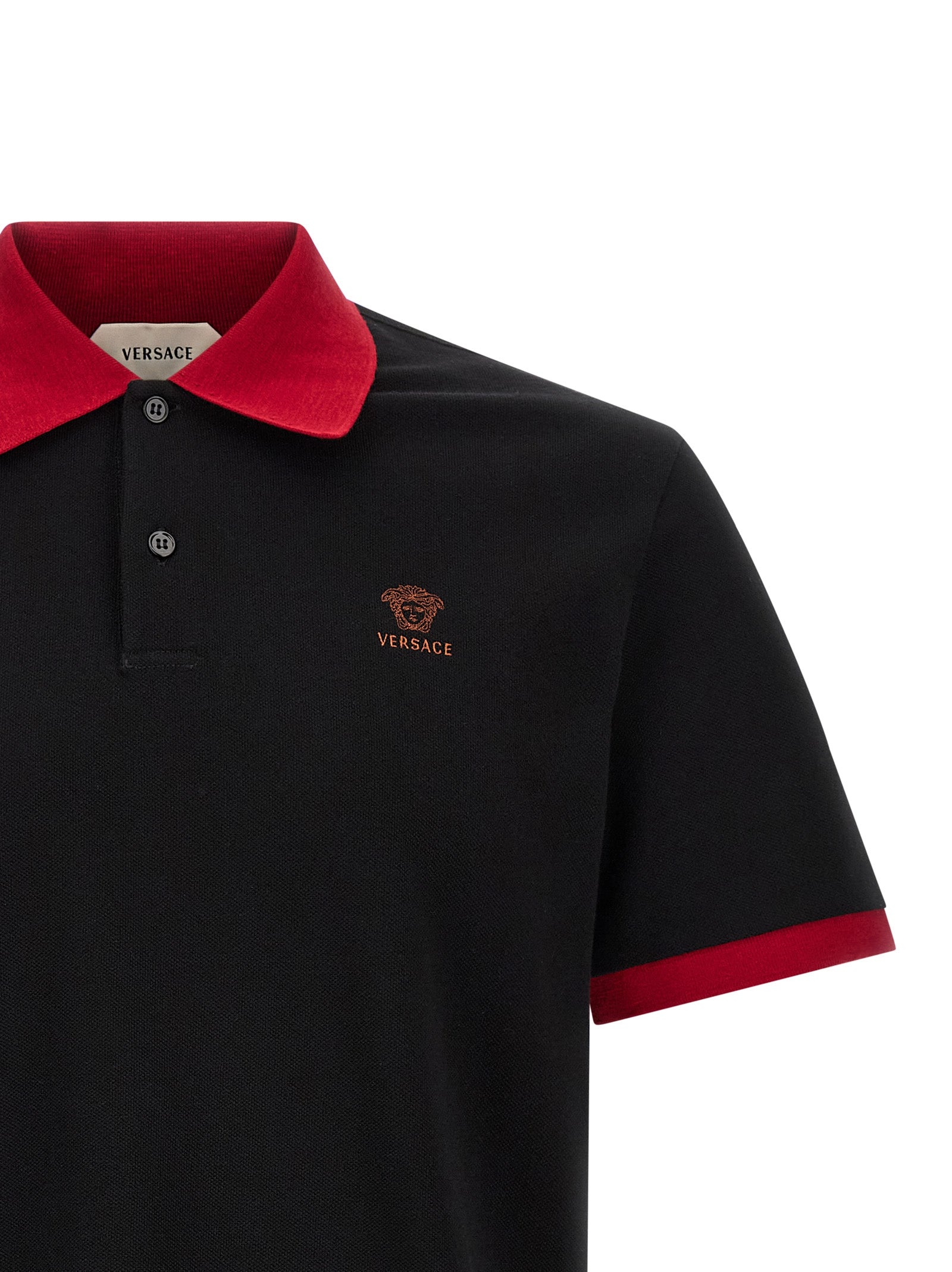 Chemise polo noire en coton de la marque Versace, avec logo et détails élégants, visible en gros plan.