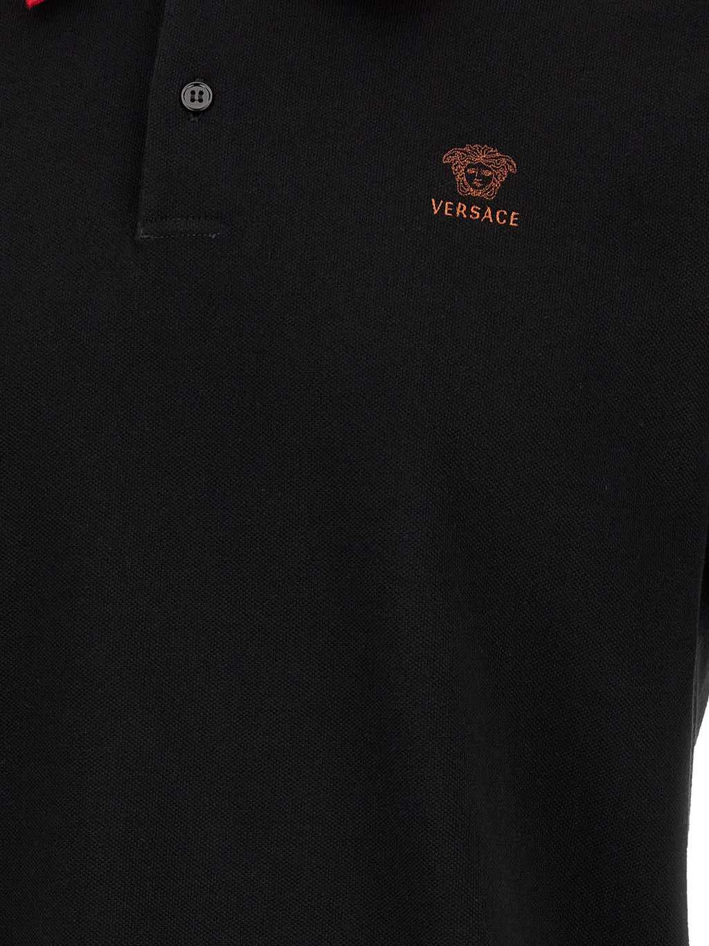 Chemise polo en coton noir de la marque Versace, avec logo distinctif sur la poitrine et col classique.
