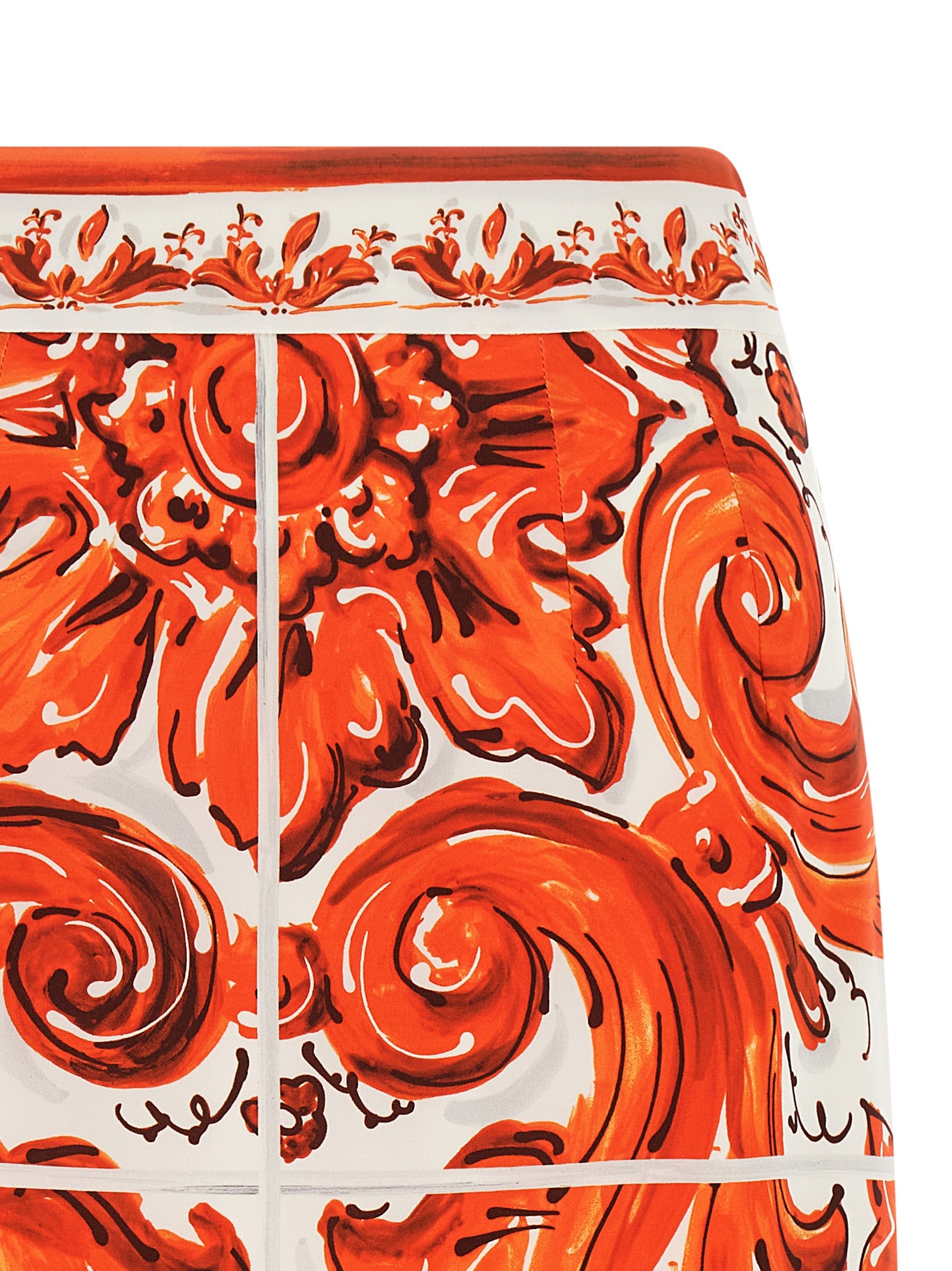 Jupe midi en soie orange de Dolce & Gabbana, coupe élégante et fluide, portée avec un style sophistiqué.