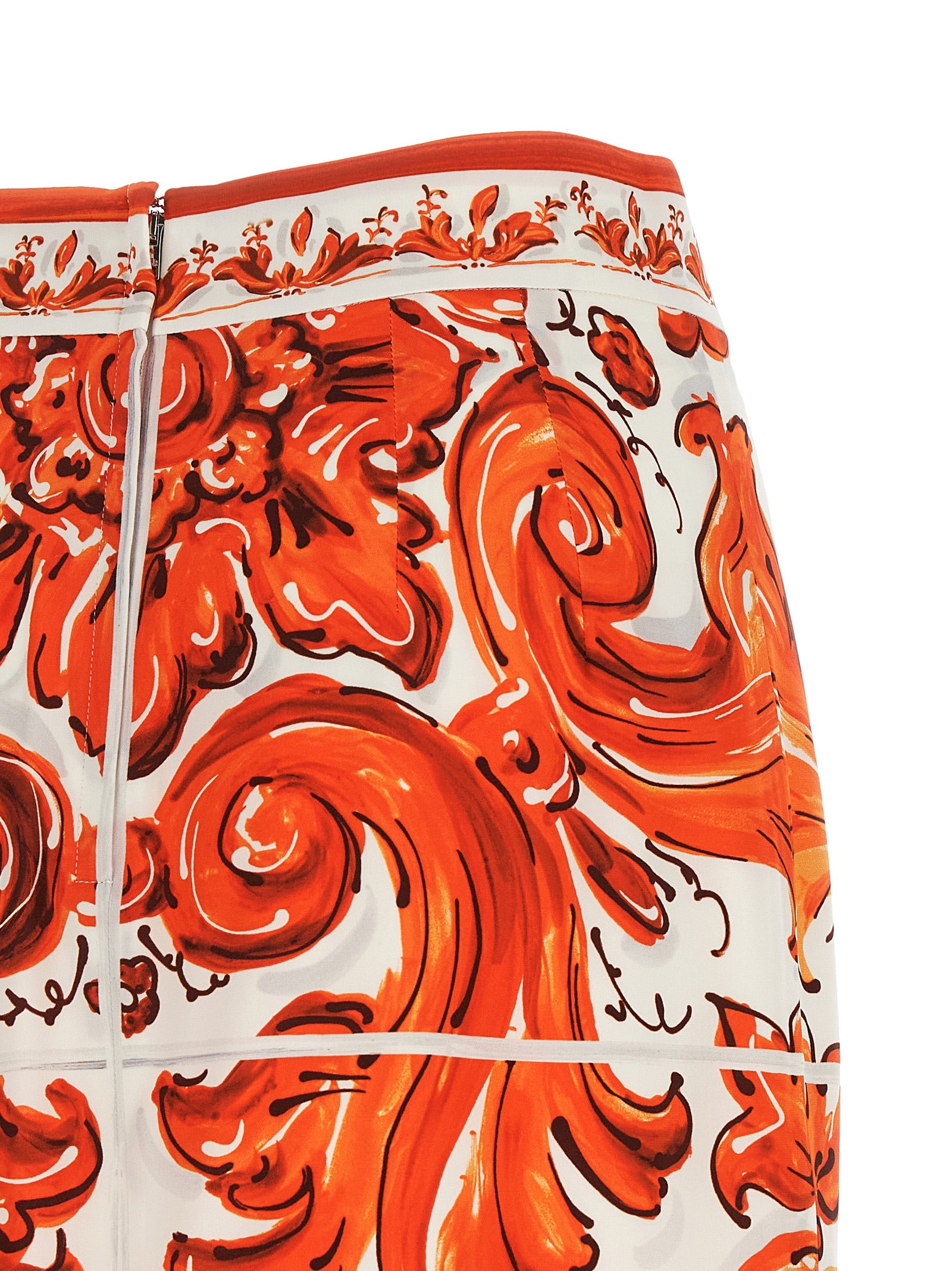 Jupe midi en soie orange Dolce & Gabbana, élégante et fluide, portée avec une silhouette sophistiquée.