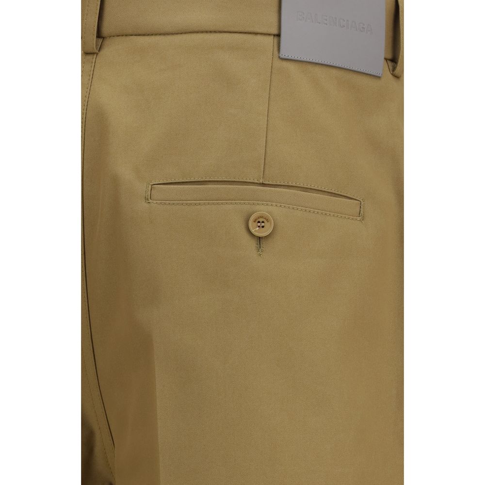 Pantalons chino beige en coton de la marque Balenciaga, coupe classique et détails élégants visibles sur l'image.