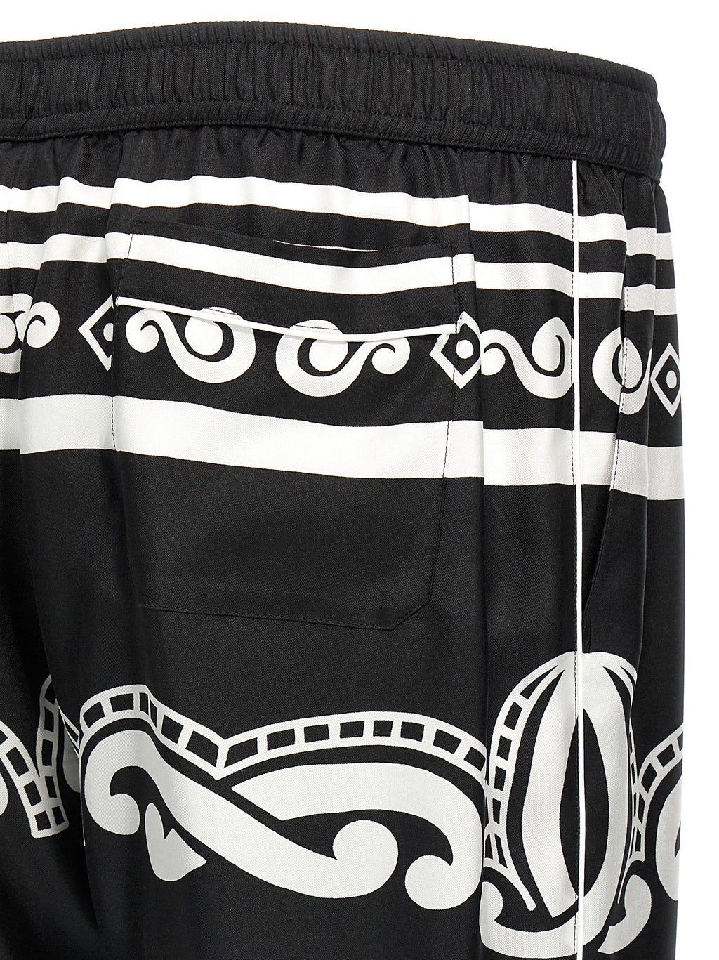Pantalons décontractés en soie bicolore de Dolce & Gabbana, coupe élégante et tissu fluide, visibles en gros plan.