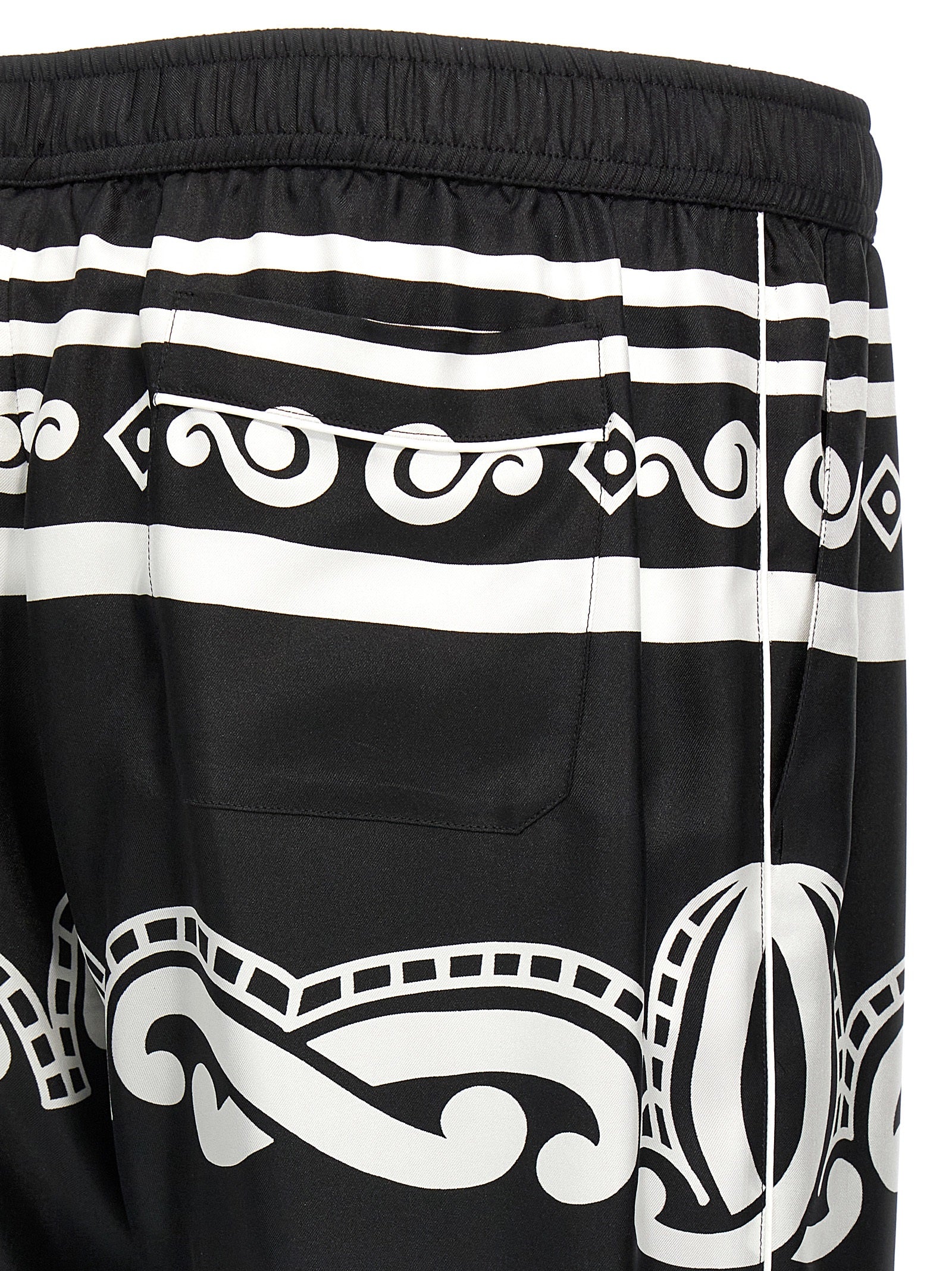 Pantalons décontractés en soie bicolore de Dolce & Gabbana, coupe élégante et tissu fluide, visibles en gros plan.