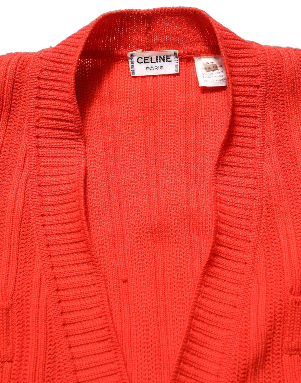 Cardigan en laine rouge de Celine avec boutons et embellissements, porté ouvert sur un fond neutre.