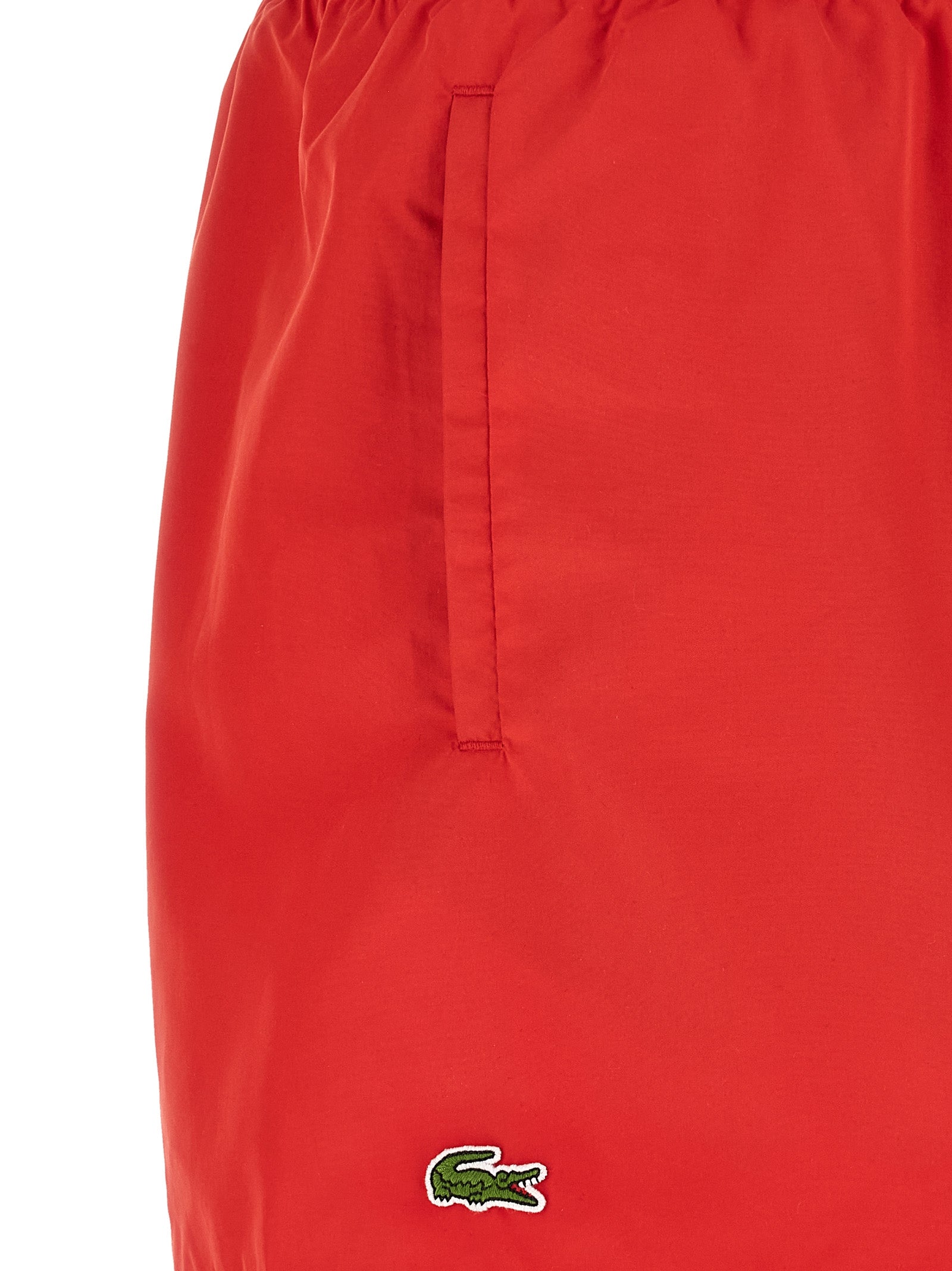 Shorts en polyester multicolores de la marque Lacoste, avec logo crocodile visible sur le devant.