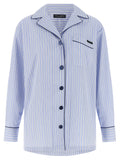 Blouse en coton bleu de Dolce & Gabbana avec manches longues et détails élégants, portée en style décontracté.