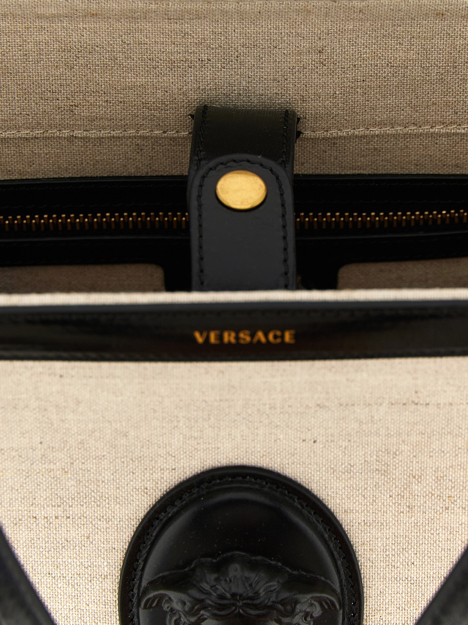 Sac cabas en cuir beige de la marque Versace, avec détails élégants et logo distinctif visible.
