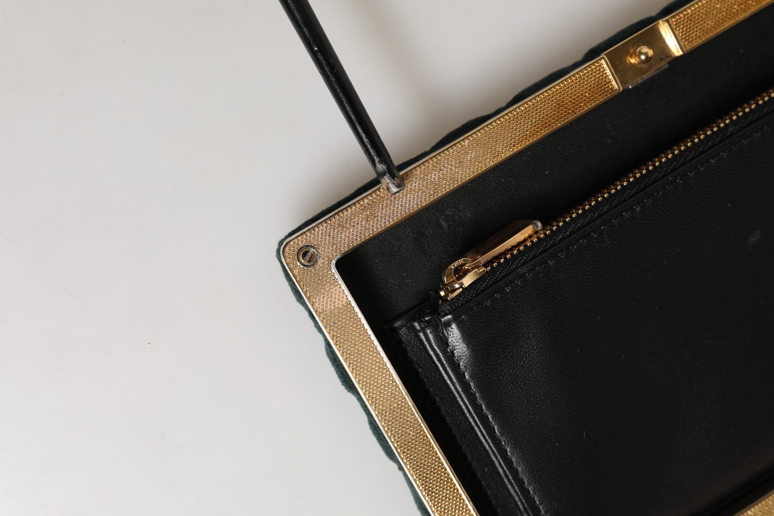 Sac pochette Dolce & Gabbana en velours noir avec cadre en or, pochette de soirée élégante et sophistiquée.