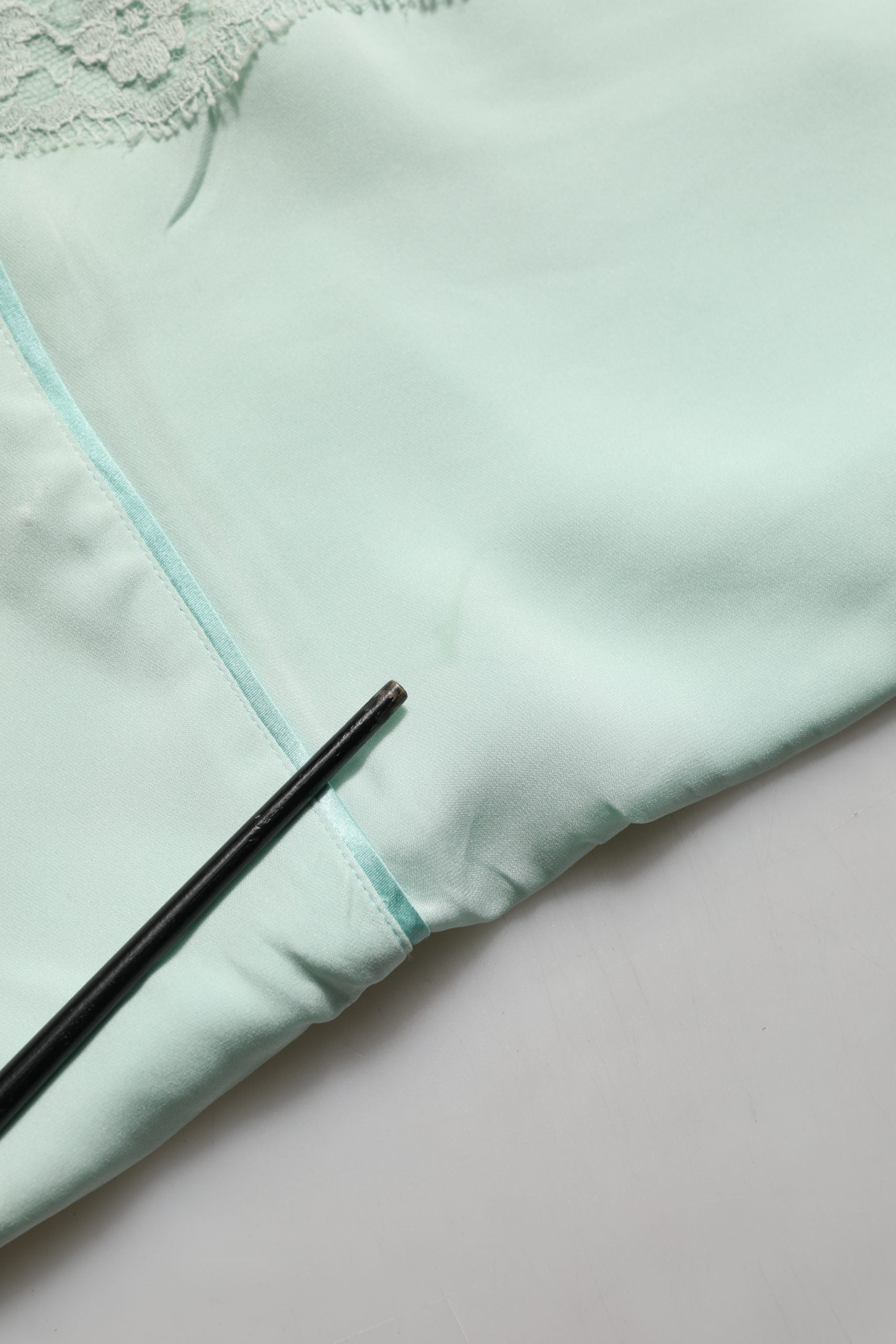 Robe maxi en soie verte menthe avec dentelle Dolce & Gabbana, abaya élégante et fluide, détail de finition en dentelle sur le haut.