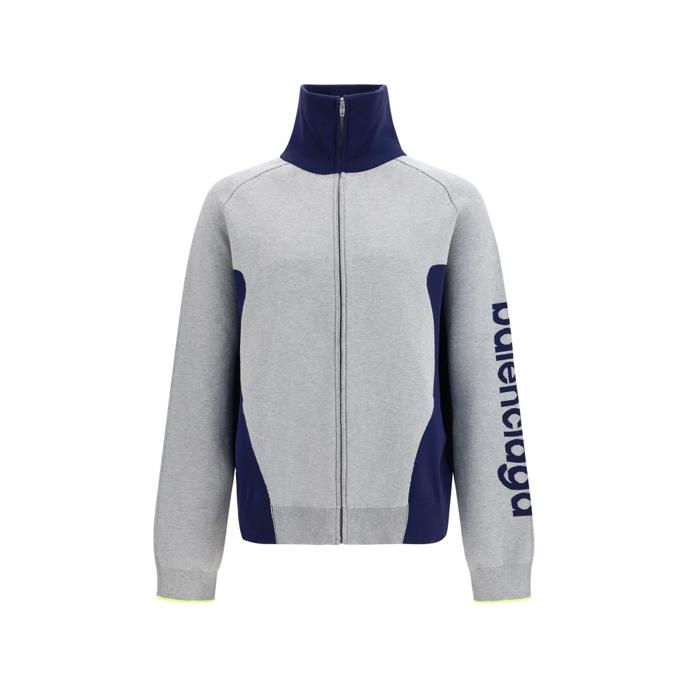 Sweat-shirt gris en coton de Balenciaga, coupe décontractée, avec logo discret sur la poitrine, porté dans un style casual.