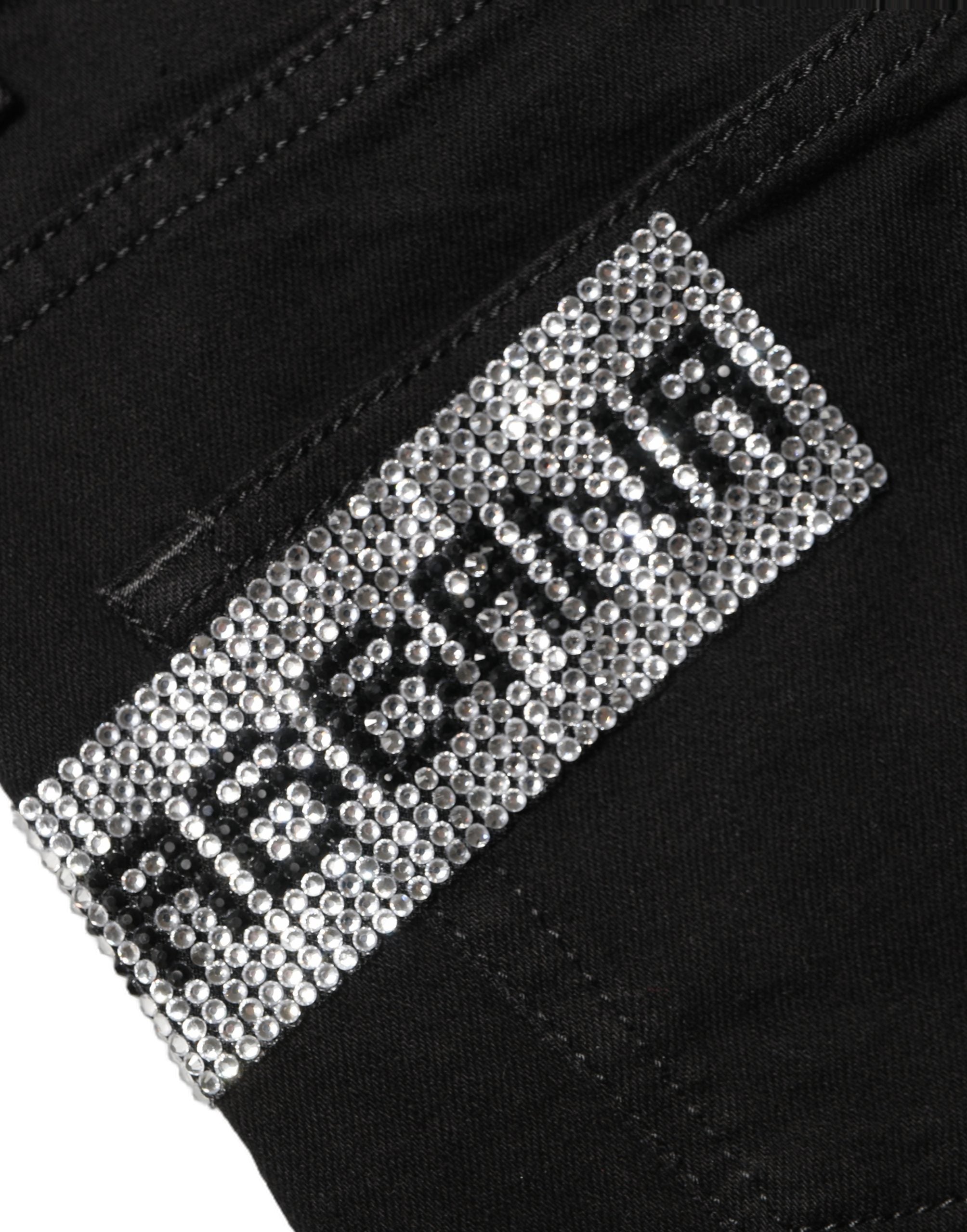 Jeans en denim noir Dolce & Gabbana Grace à taille haute avec strass, visible en gros plan sur l’image.