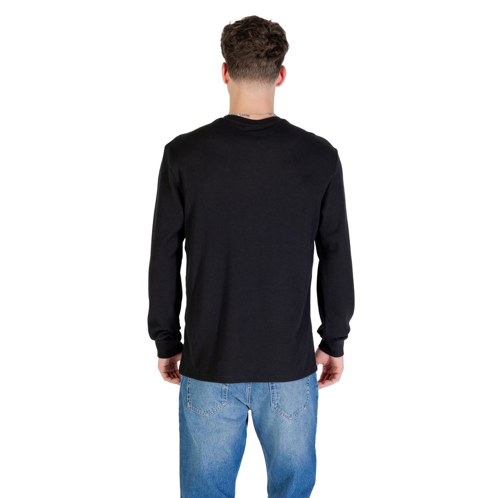 T-shirt à manches longues en coton noir de Calvin Klein Jeans, vue frontale avec logo discret sur la poitrine.