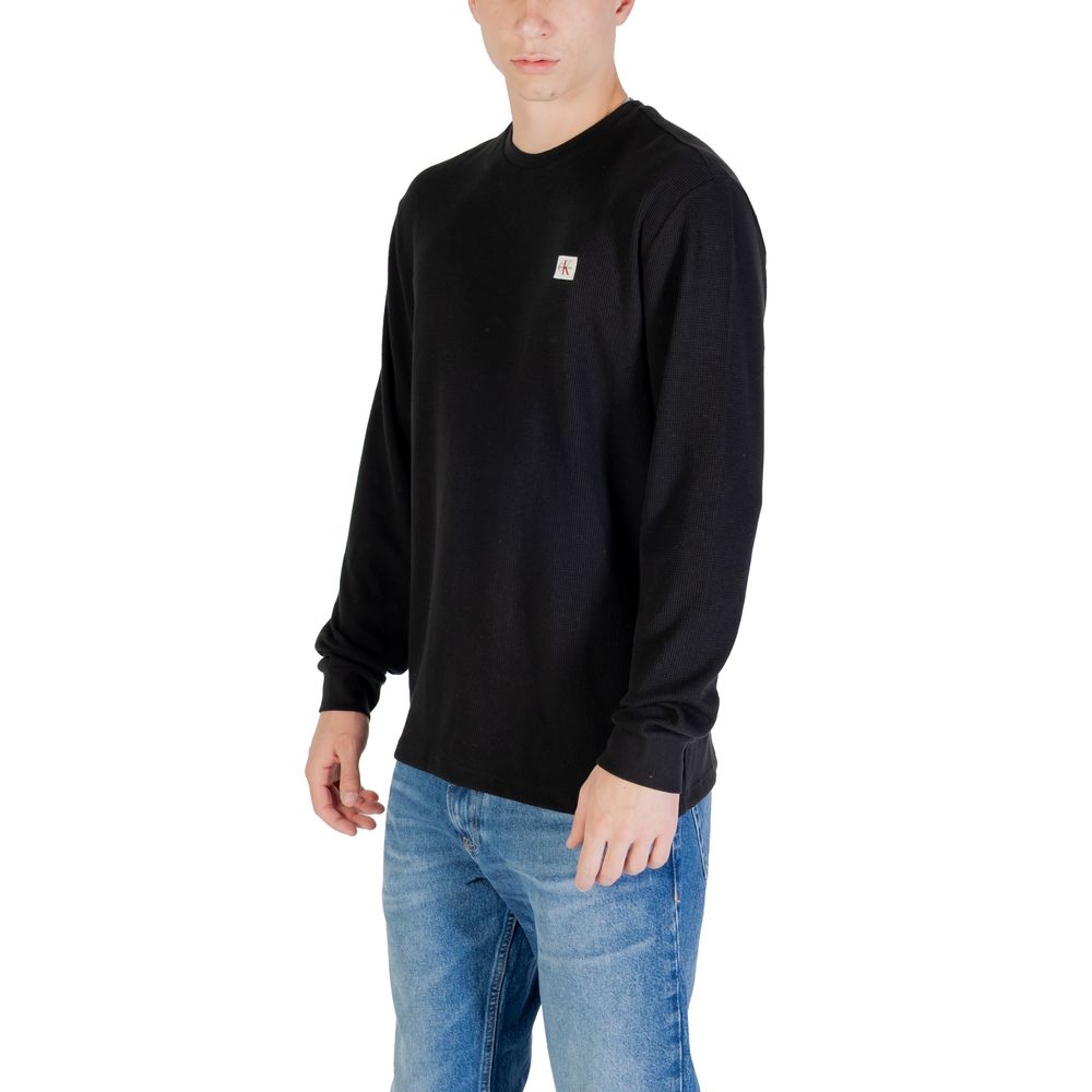 T-shirt noir à manches longues en coton de Calvin Klein Jeans, affichant un design simple et élégant.