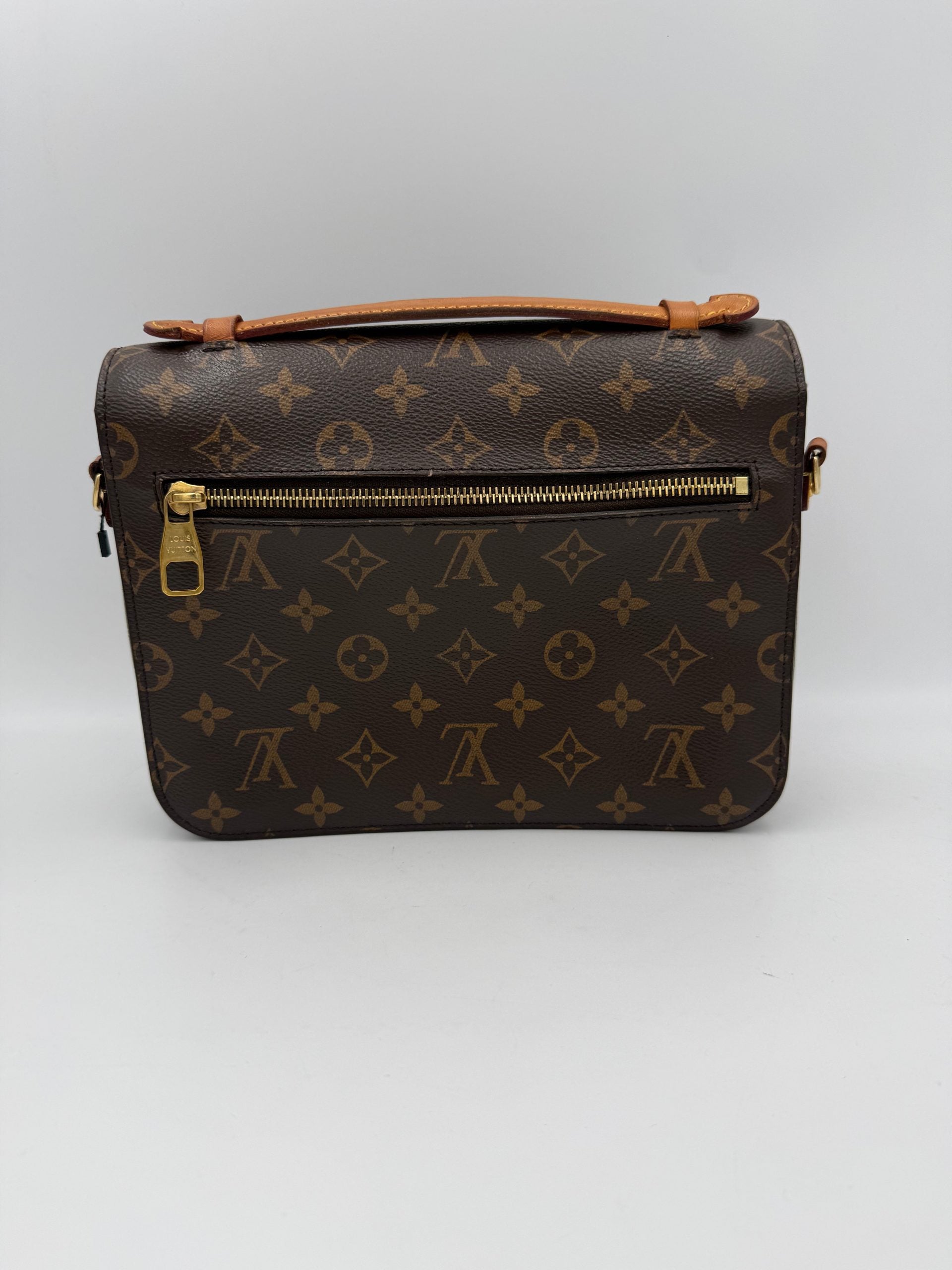 Sac à main Louis Vuitton Metis Monogram, en toile emblématique, avec poignées en cuir et fermeture métallique visible.