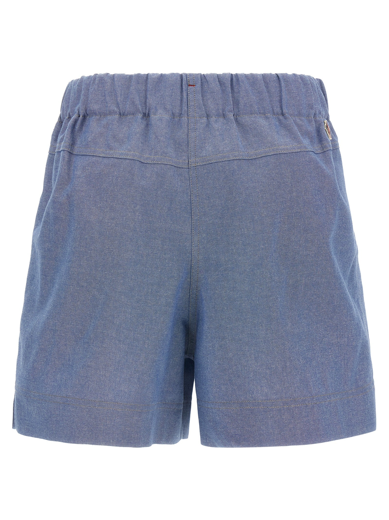 Shorts bermuda en coton bleu de la marque Moncler Grenoble, style décontracté et confortable, visibles en détail dans l'image.
