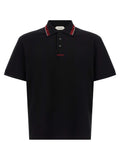 Chemise polo noire en coton de la marque Versace, avec logo distinctif visible sur la poitrine.