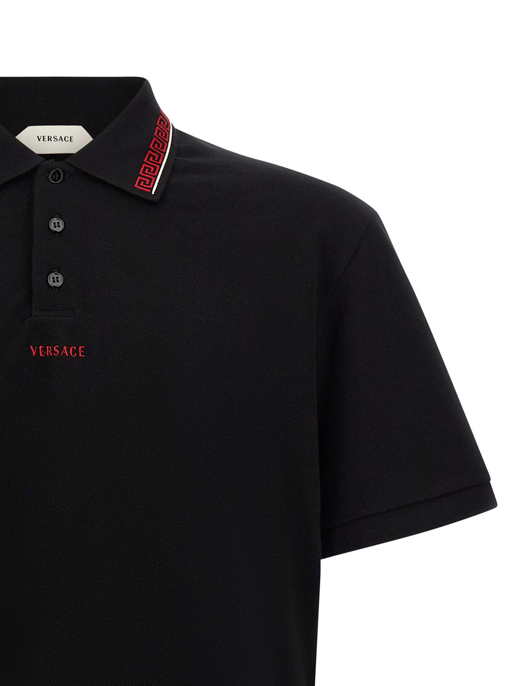 Chemise polo en coton noir de la marque Versace, visible avec col classique et logo distinctif sur la poitrine.
