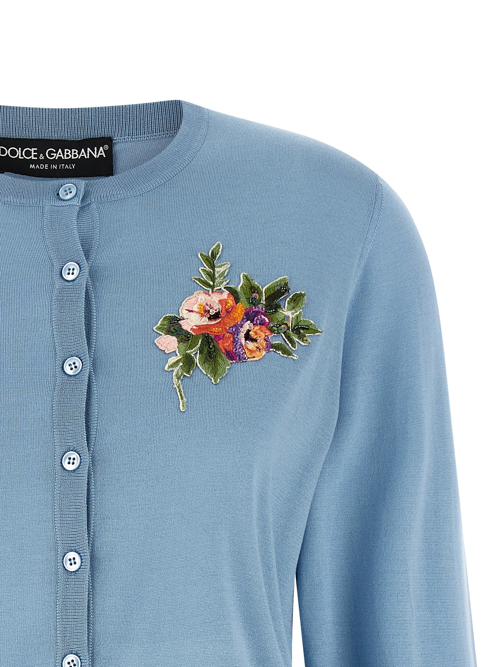 Cardigan en soie bleue Dolce & Gabbana porté, détails élégants et texture douce visible sur le vêtement.