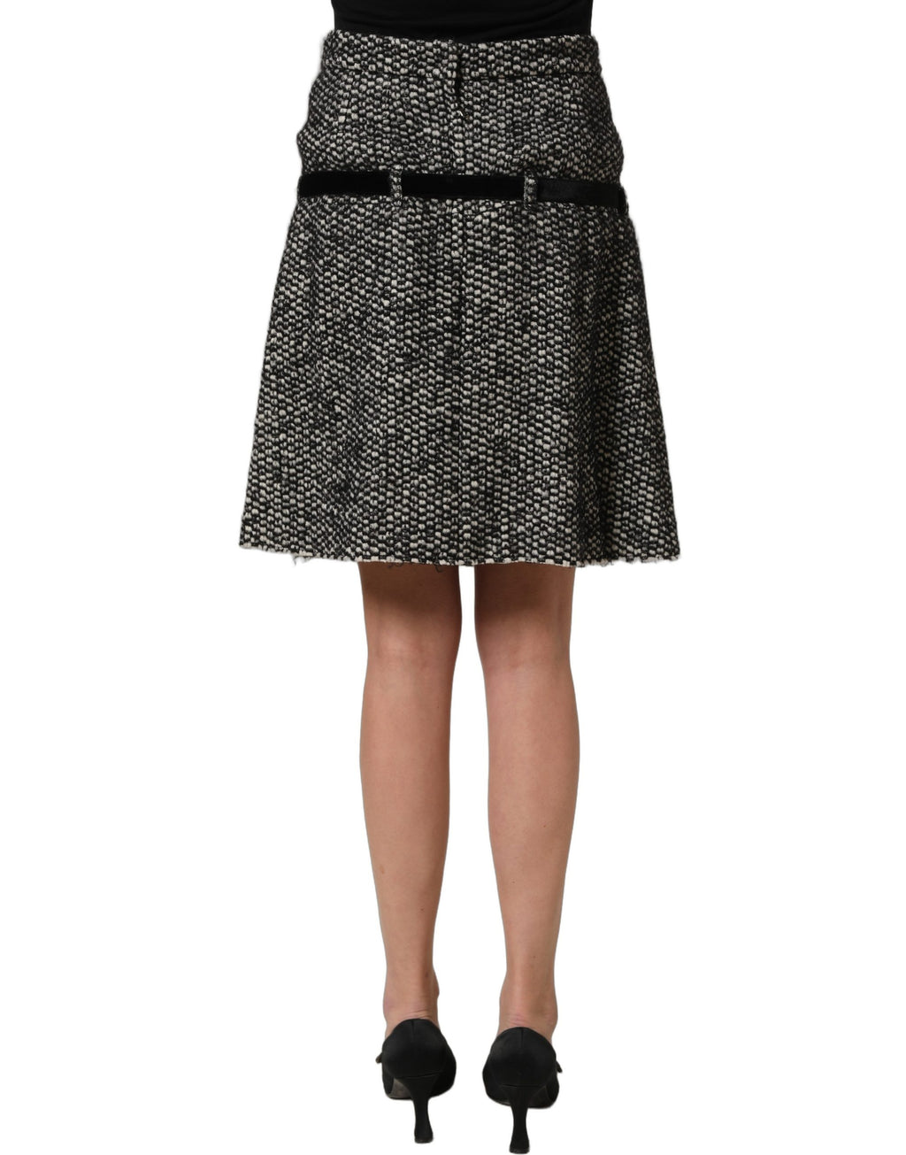 Jupe plissée en tweed noir et blanc Dolce & Gabbana à taille haute, élégante et tendance, visible en gros plan.