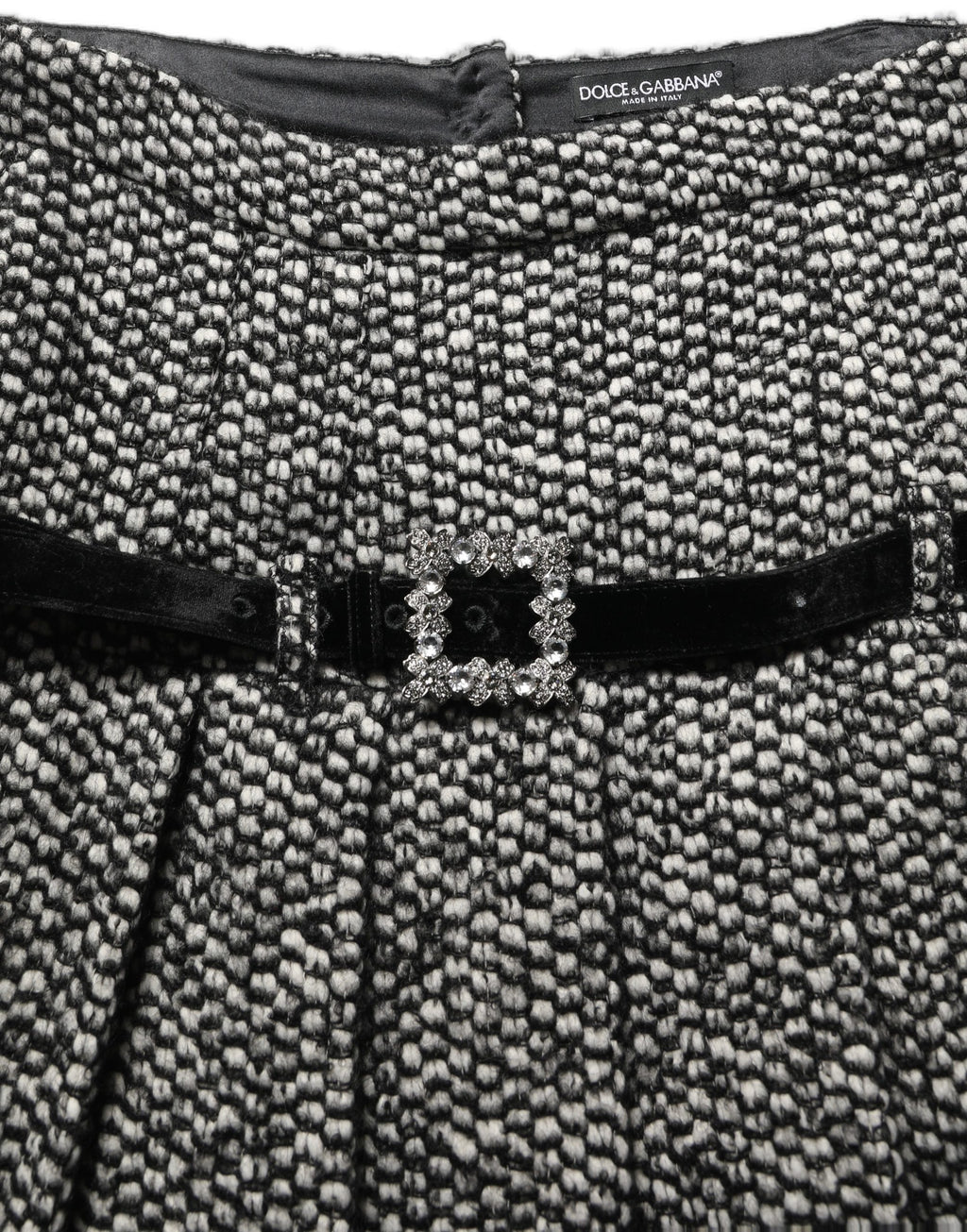 Jupe plissée à taille haute en tweed noir et blanc de Dolce & Gabbana, style élégant et sophistiqué.