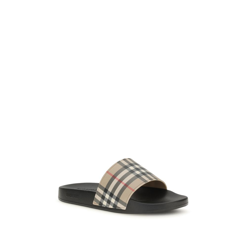 Sandales en caoutchouc noires Burberry, élégantes et confortables, avec logo emblématique visible sur le dessus.