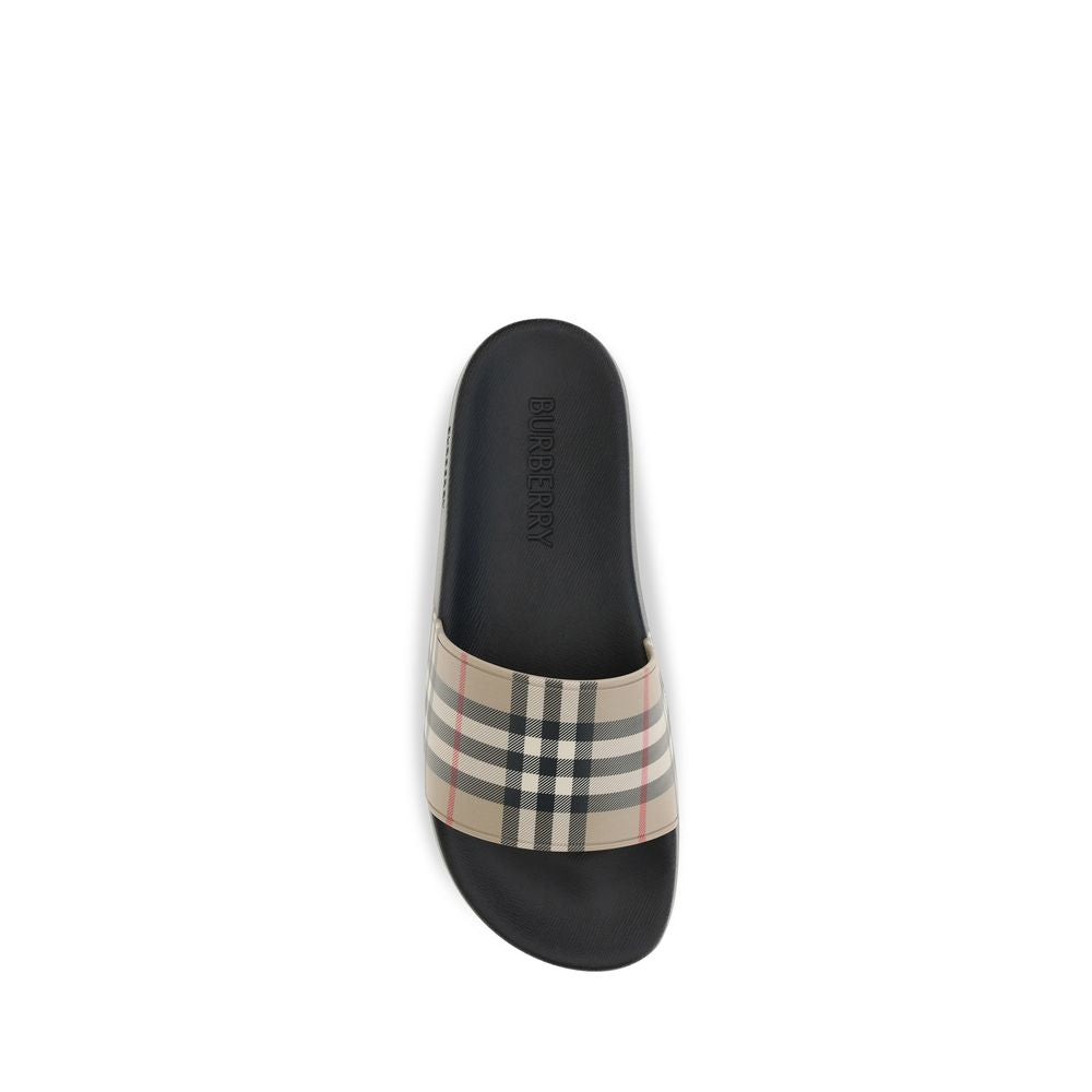 Sandales en caoutchouc noires de Burberry, style slide avec logo emblématique sur la bride, pour un look décontracté et élégant.