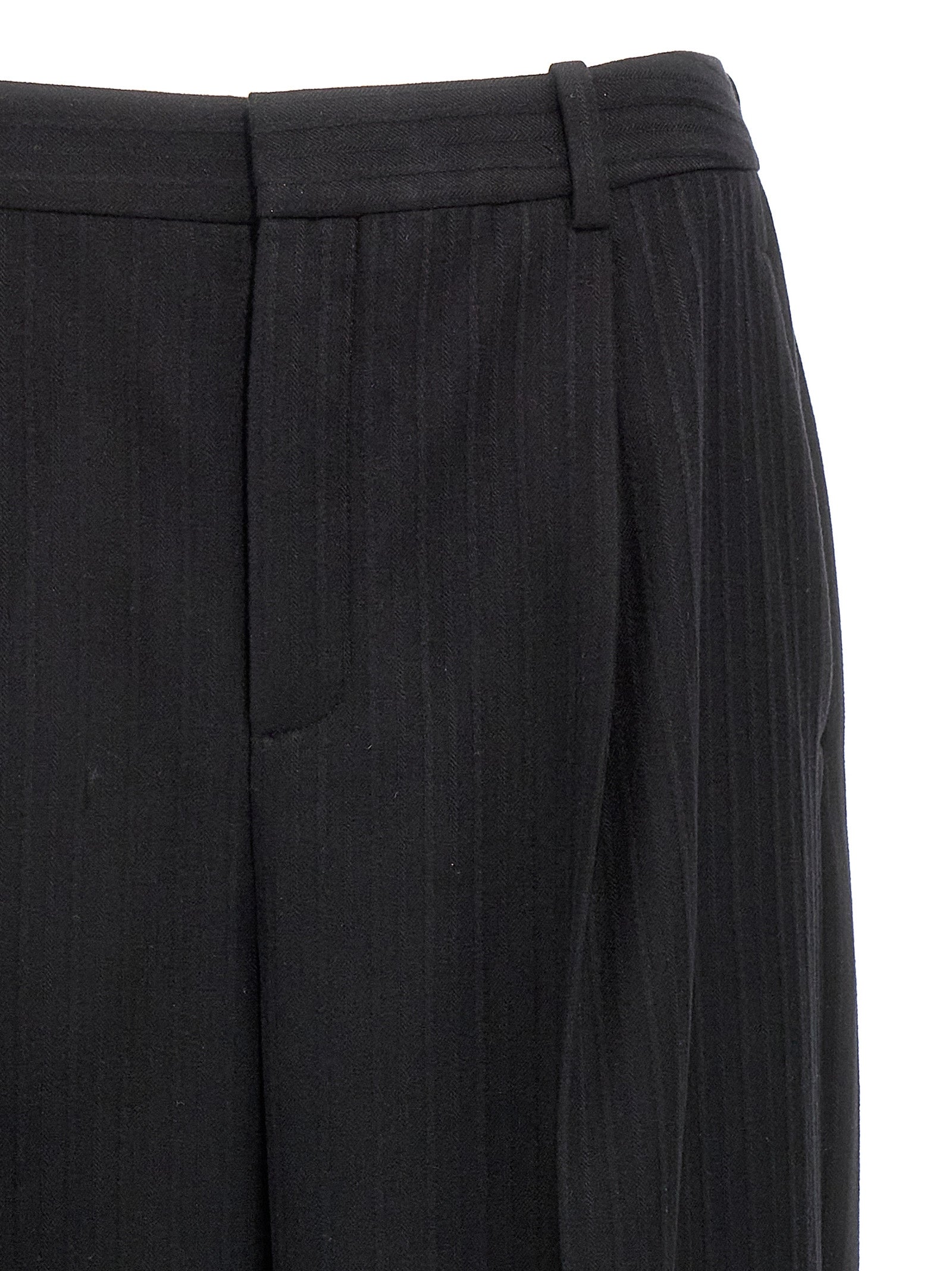 Pantalon en laine noire Saint Laurent pour femme, coupe élégante et ajustée, porté avec une chemise blanche.