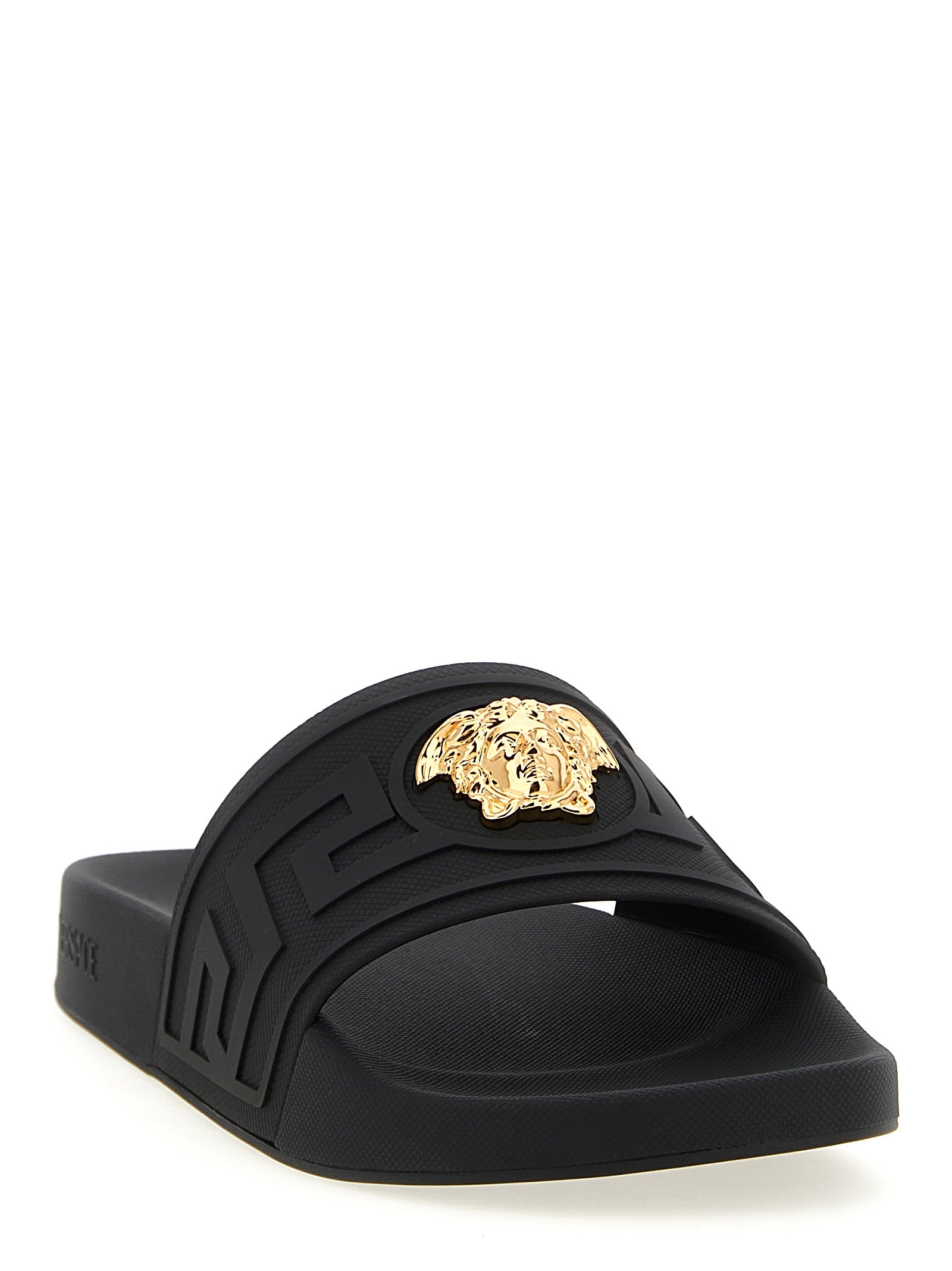 Sandales en verre noir Versace, élégantes et modernes, avec logo Versace visible sur la bande en verre noir.