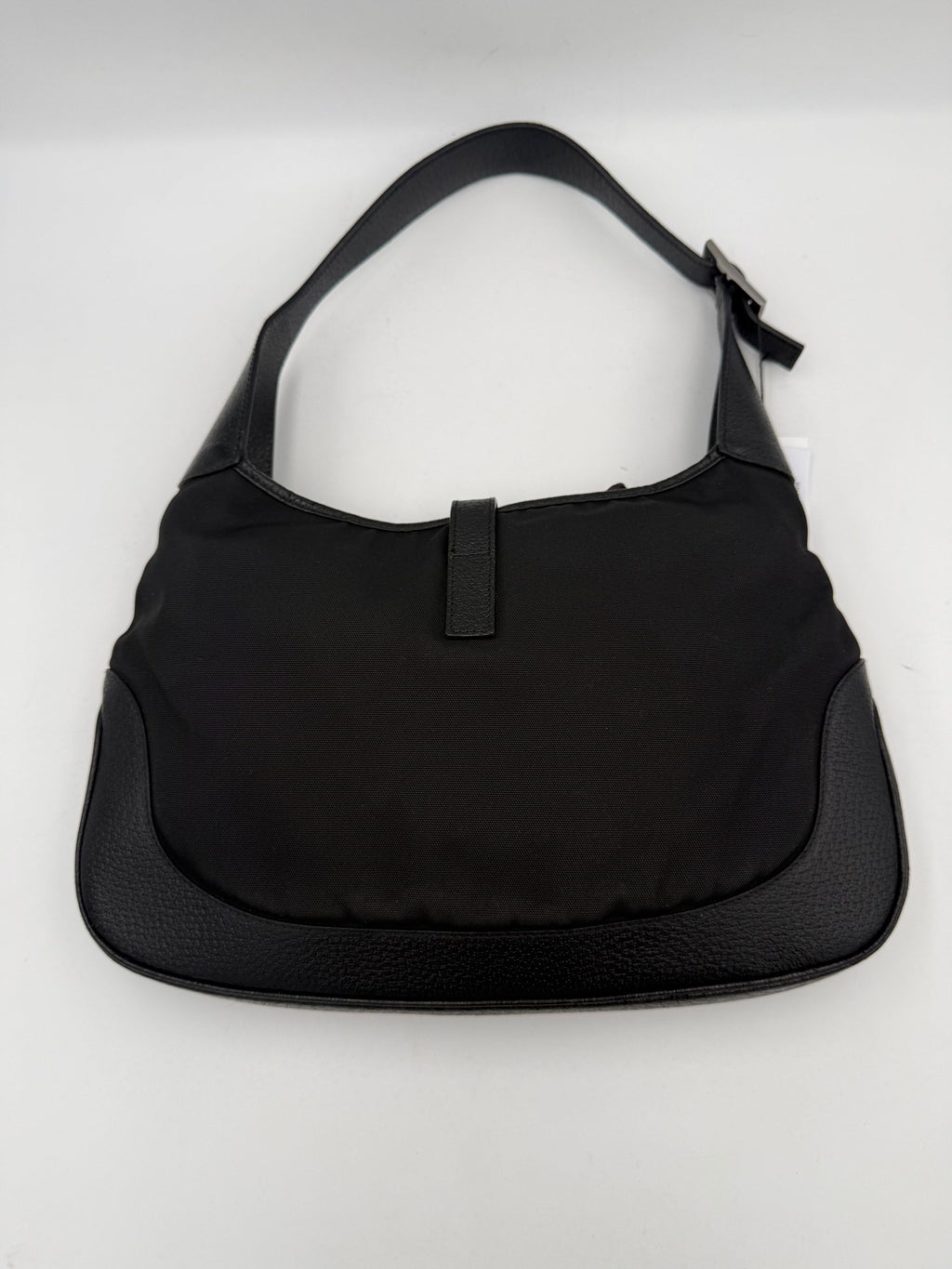 Sac à main Gucci Jackie en cuir et toile avec poignée en cuir et logo Gucci visible.