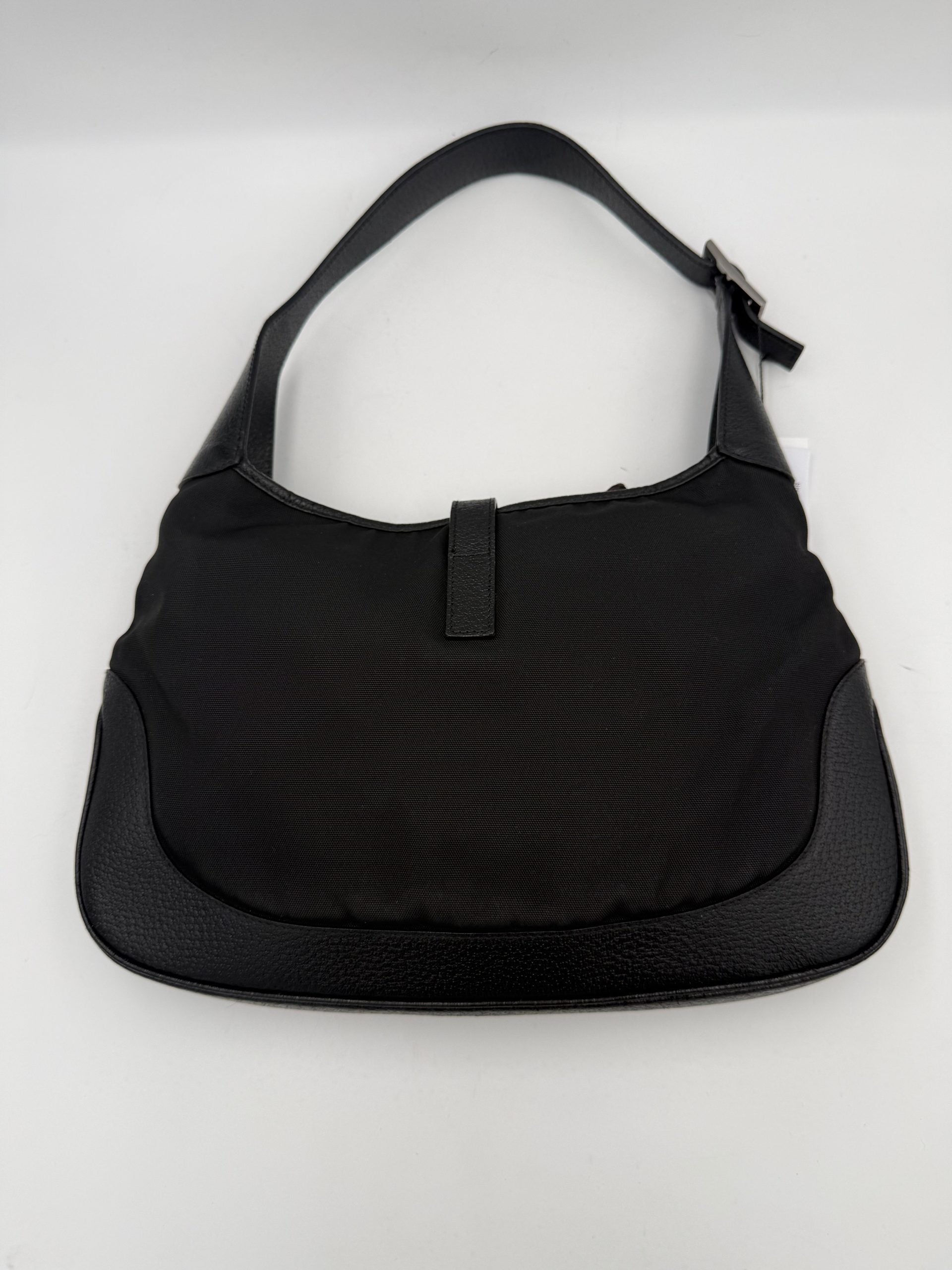 Sac à main Gucci Jackie en cuir et toile avec poignée en cuir et logo Gucci visible.