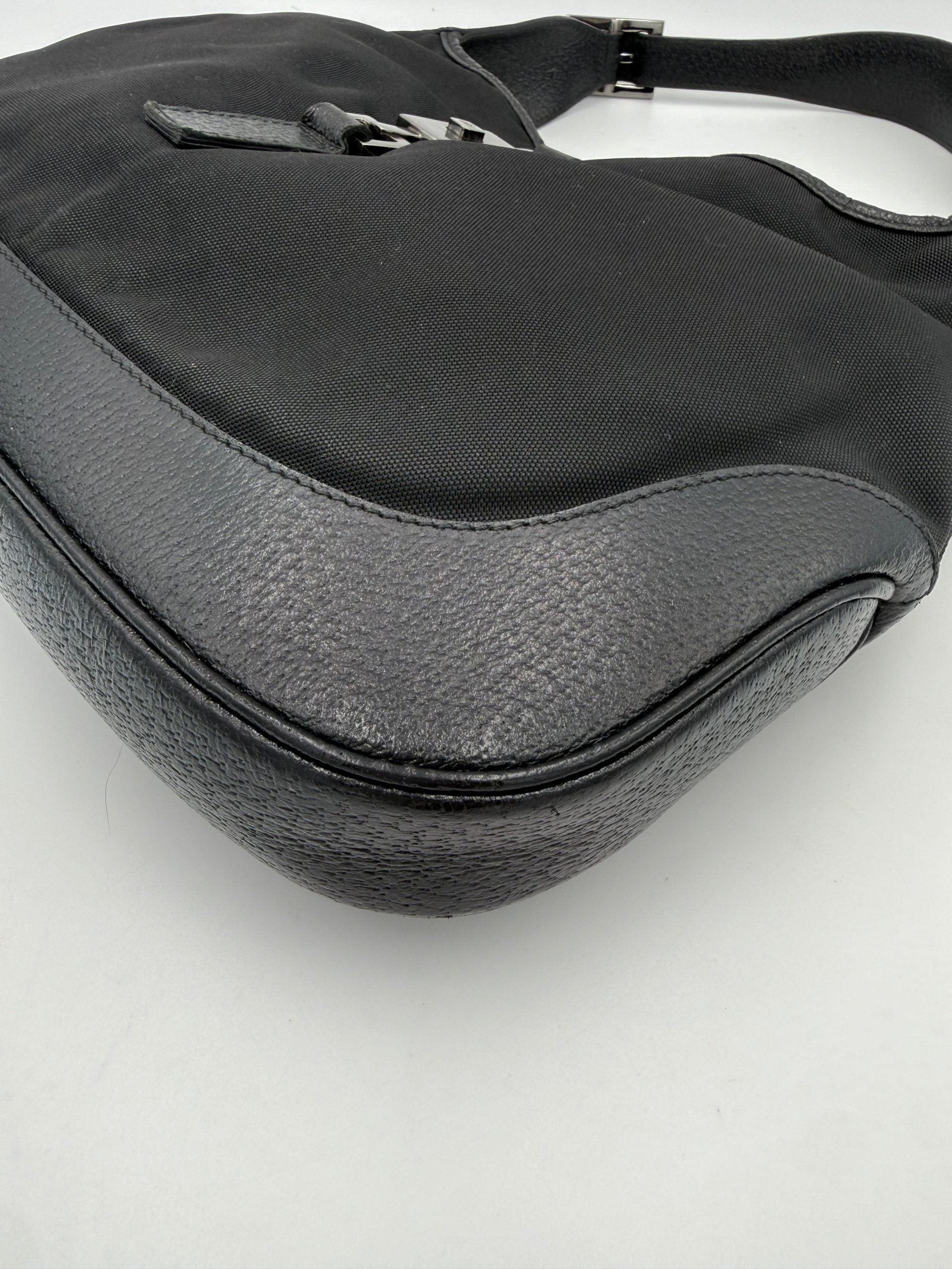 Sac à main Gucci Jackie en cuir et toile, élégant et sophistiqué, avec détails en métal doré et logo Gucci visible.