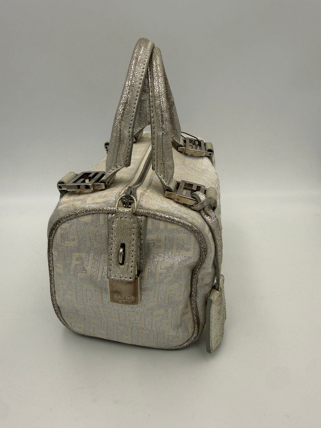 Sac à main Fendi Mini Bauletto FF Zucchino en lamé, avec motif emblématique et poignée en cuir, visible en gros plan.