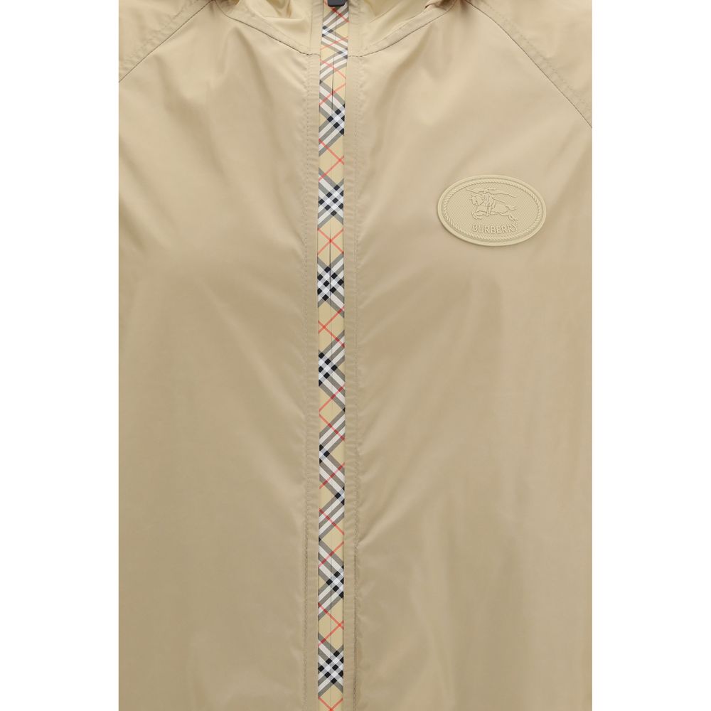 Veste en nylon beige de Burberry, coupe-vent légère et élégante, avec logo emblématique sur la poitrine.
