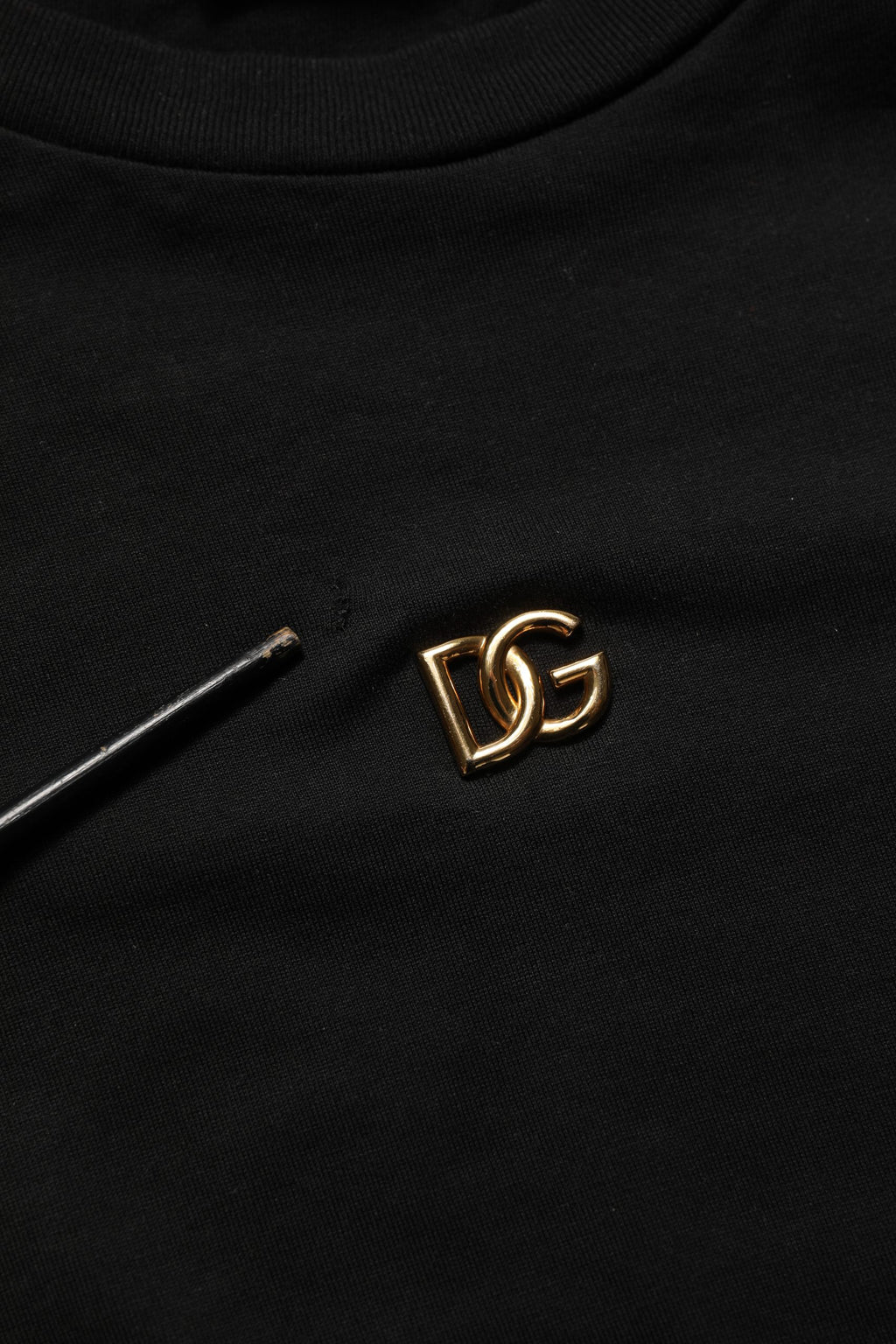 T-shirt noir Dolce & Gabbana avec logo en métal DG à manches courtes, style élégant et moderne.