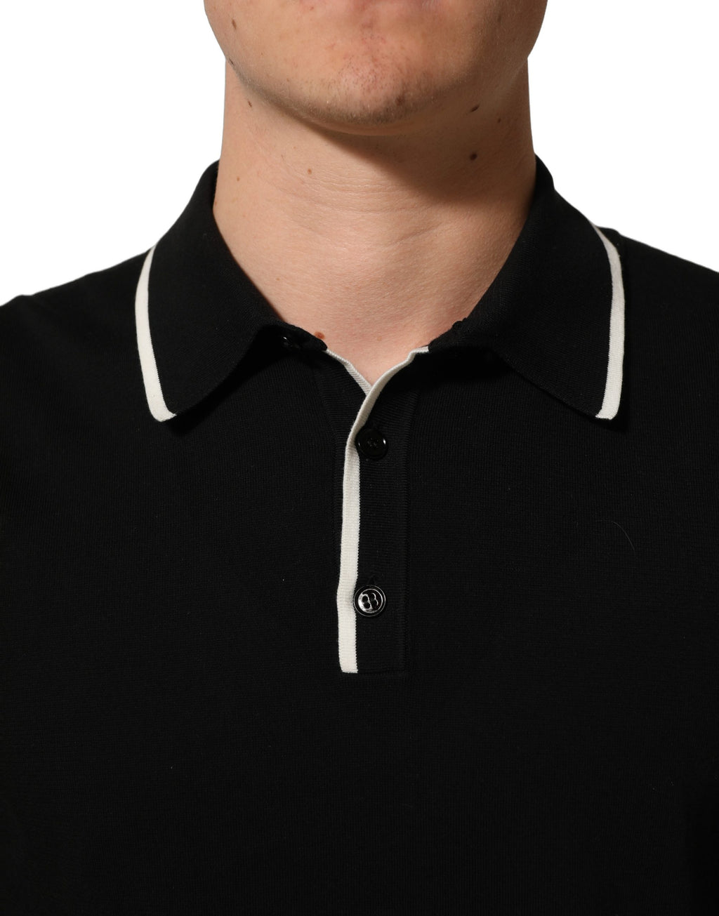 Polo Dolce & Gabbana en coton noir à col et manches courtes, vue de face, détails du tissu et du col visible.