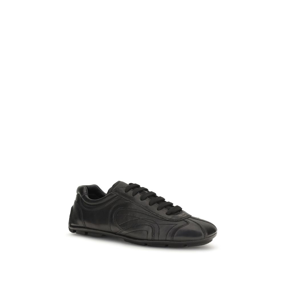 Baskets basses Prada en cuir d'agneau noir, style décontracté et élégant, avec logo Prada visible sur le côté.