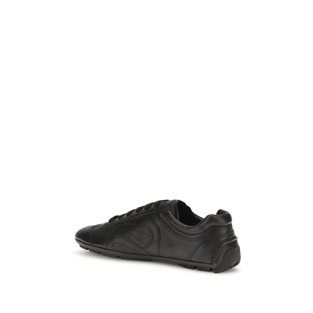 Sneakers basses Prada en cuir d'agneau noir, design élégant et moderne, visibles sur fond neutre.