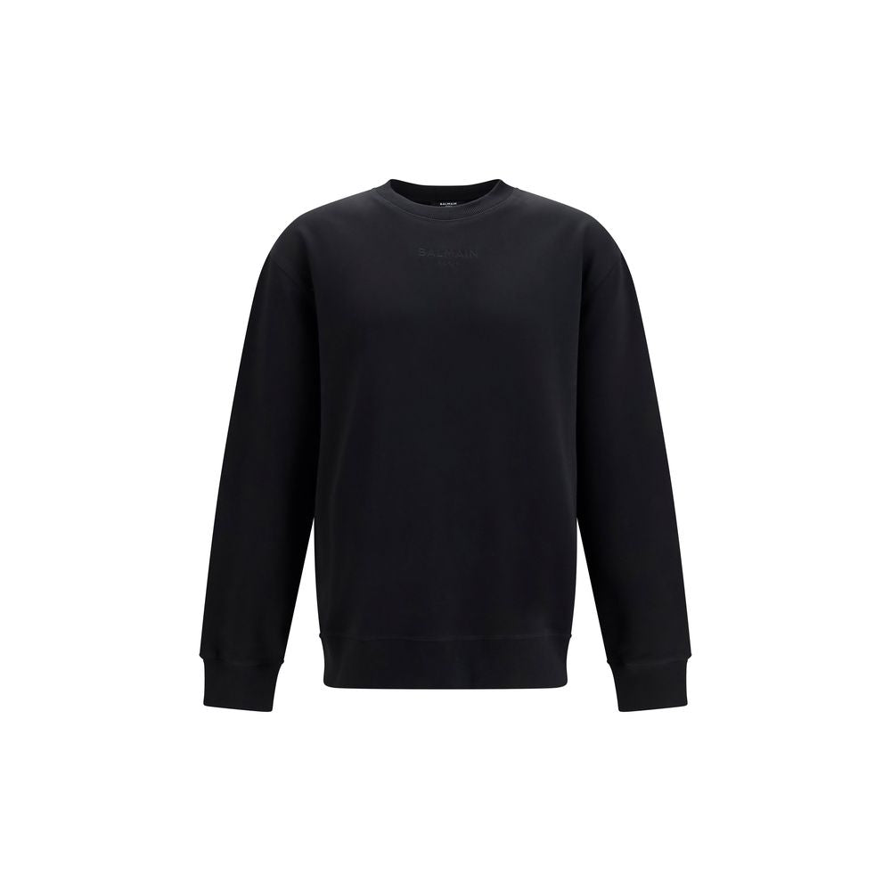 Sweat-shirt noir en coton de Balmain avec logo brodé, porté façon décontractée, vue de face.