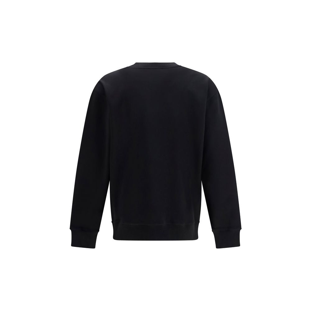 Sweat-shirt noir en coton de Balmain avec logo brodé, porté décontracté, vue en gros plan sur le tissu et les détails du design.